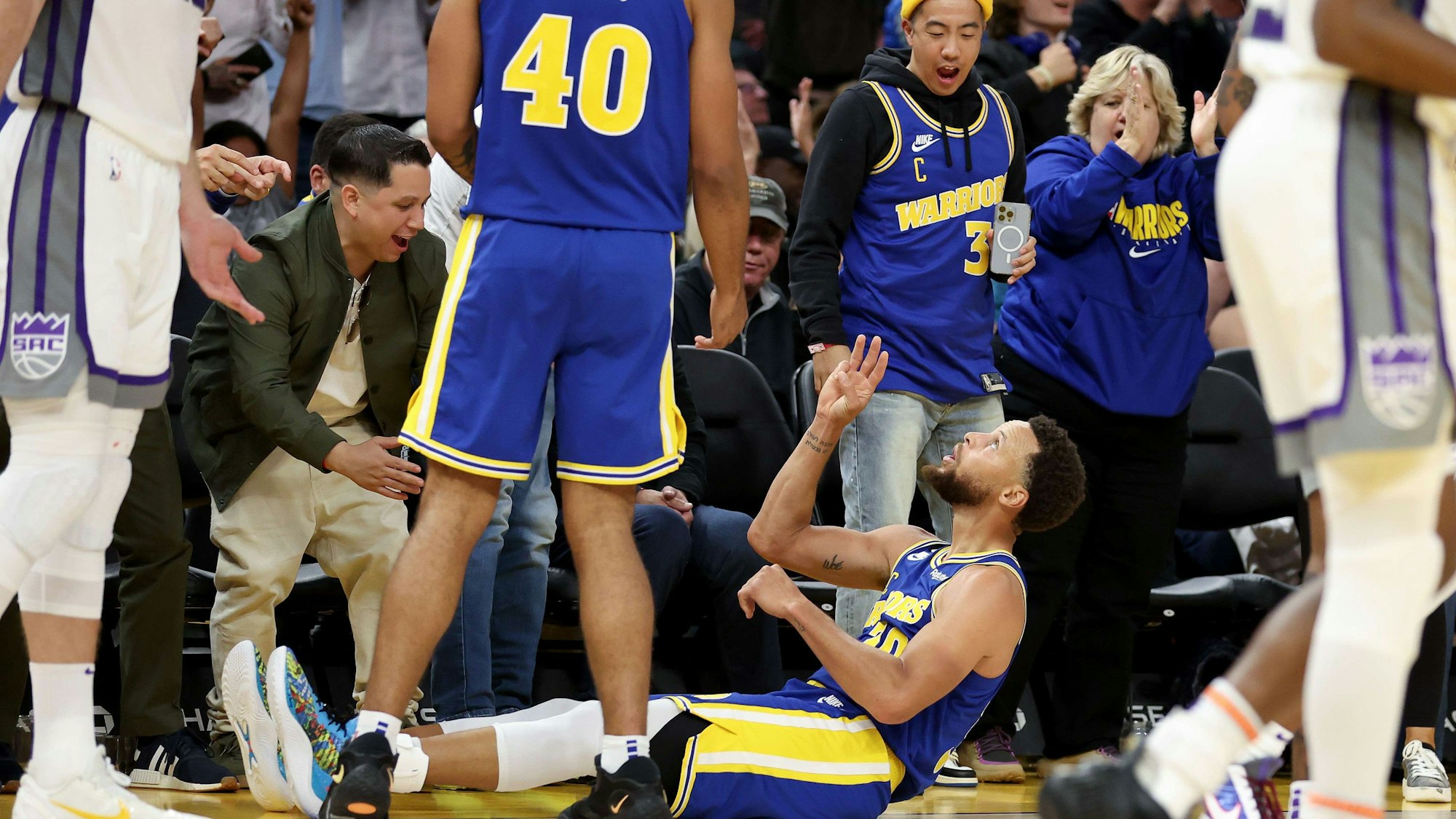 Stephen Curry von den Golden State Warriors feiert einen Dreier auf dem Hallenboden.