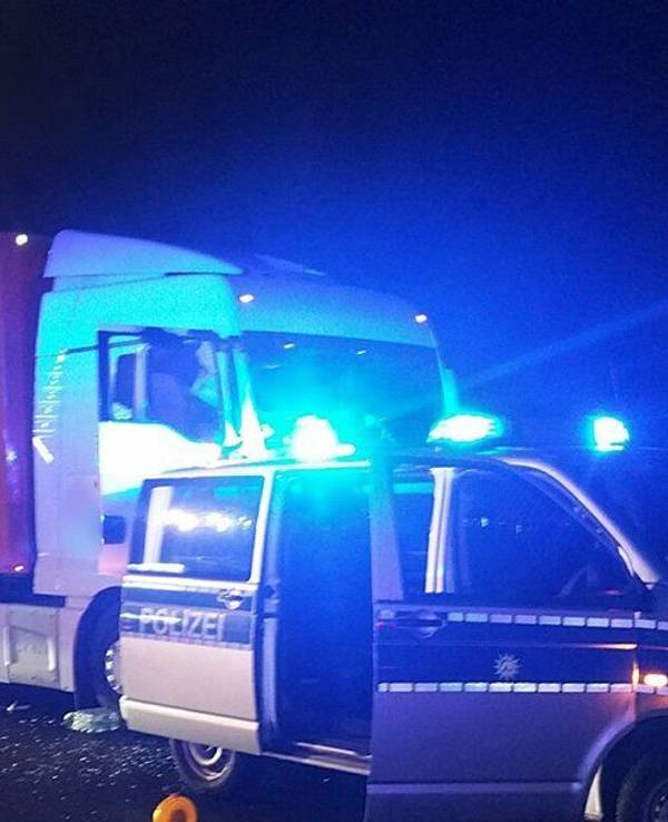 Ein Streifenwagen steht auf der Autobahn 1 vor einem Lastwagen.