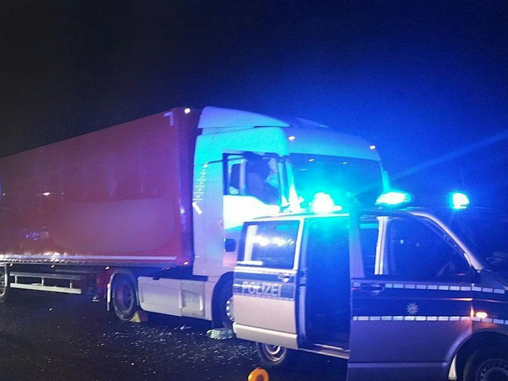 Ein Streifenwagen steht auf der Autobahn 1 vor einem Lastwagen.