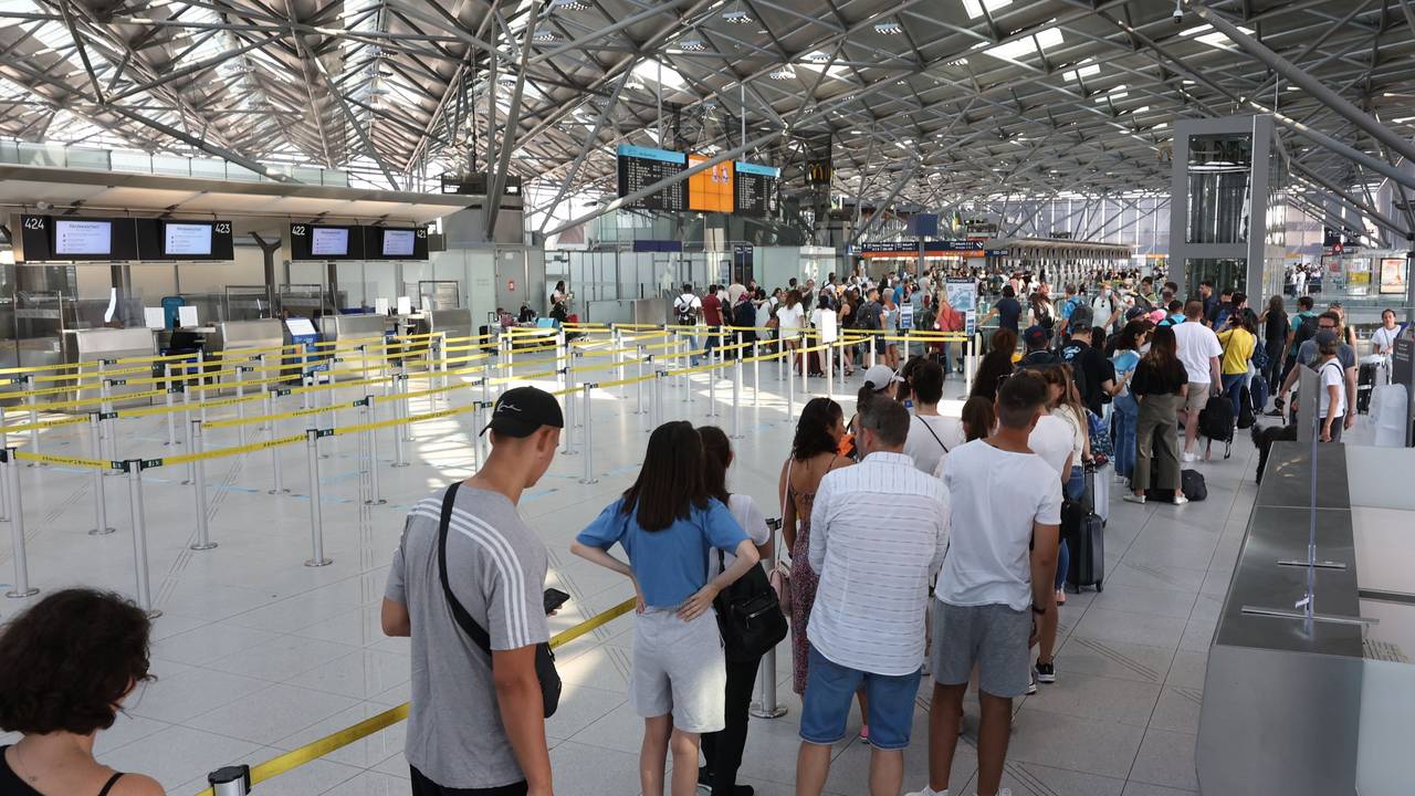 Lange Schlange am Flughafen Köln/Bonn. Reisende kommen mit Verspätung in den Urlaub.