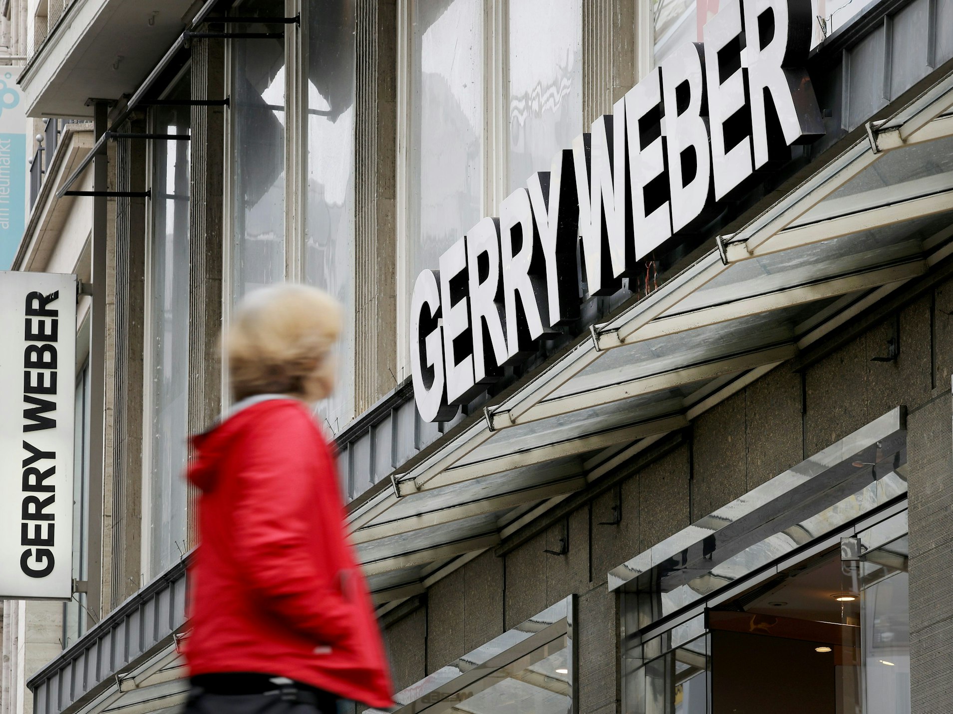 Eine Passantin geht in Köln an einer Filiale des Modeunternehmens Gerry Weber vorbei.
