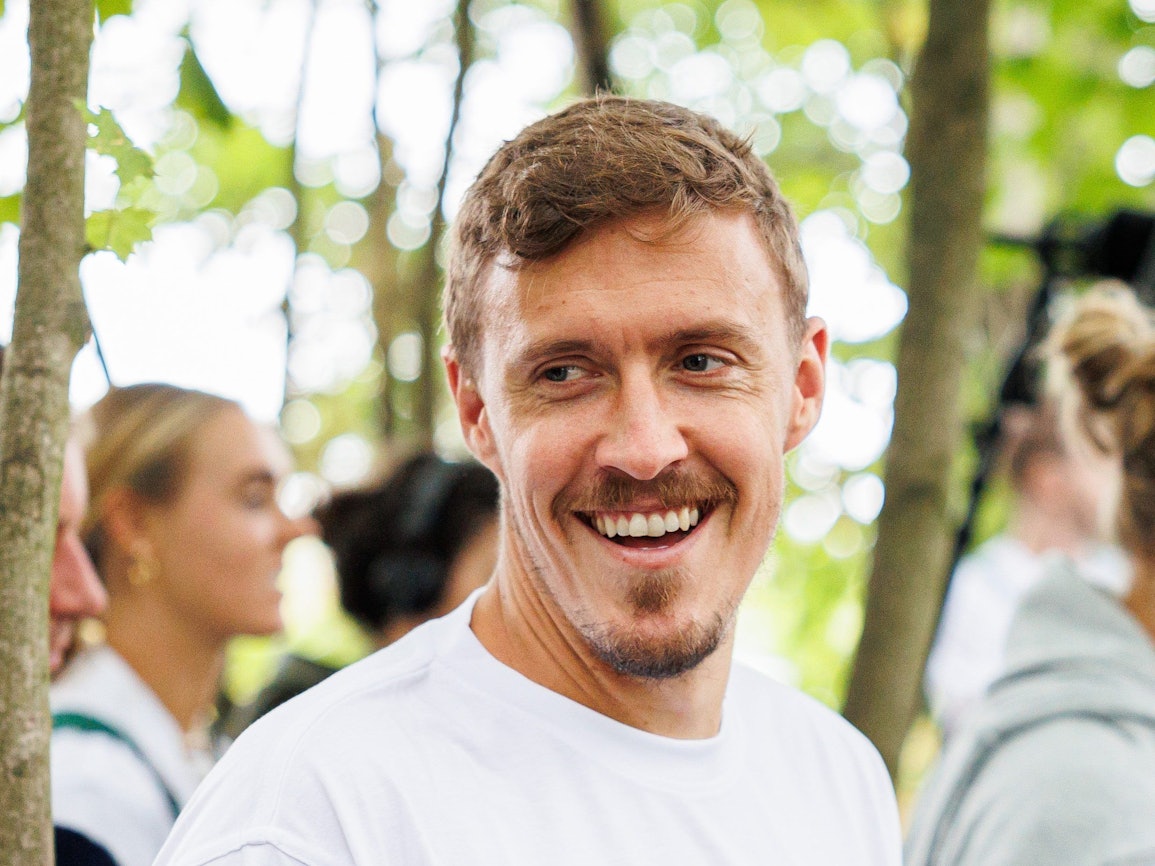 Max Kruse steht beim Besuch vom Bauernhof „Kinder-Tiere-Kommunikation“ am Zaun eines Geheges.