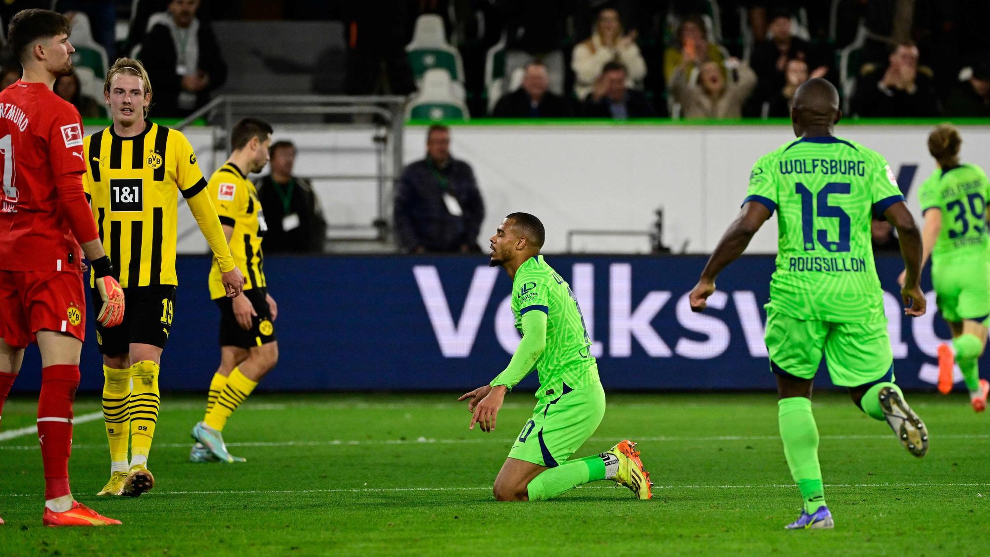 Lukas Nmecha kniet nach seinem Treffer gegen Borussia Dortmund in der Bundesliga auf dem Rasen. Die WM wird der Stürmer vom VfL Wolfsburg verpassen.