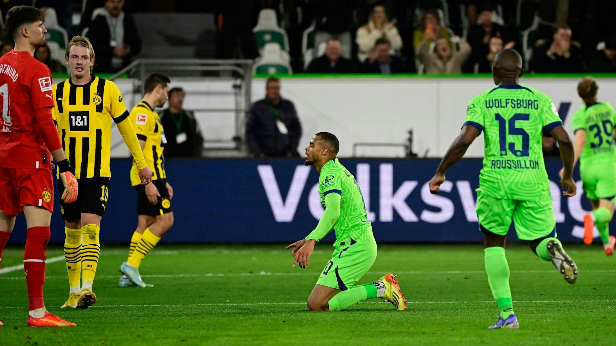 Lukas Nmecha kniet nach seinem Treffer gegen Borussia Dortmund in der Bundesliga auf dem Rasen. Die WM wird der Stürmer vom VfL Wolfsburg verpassen.