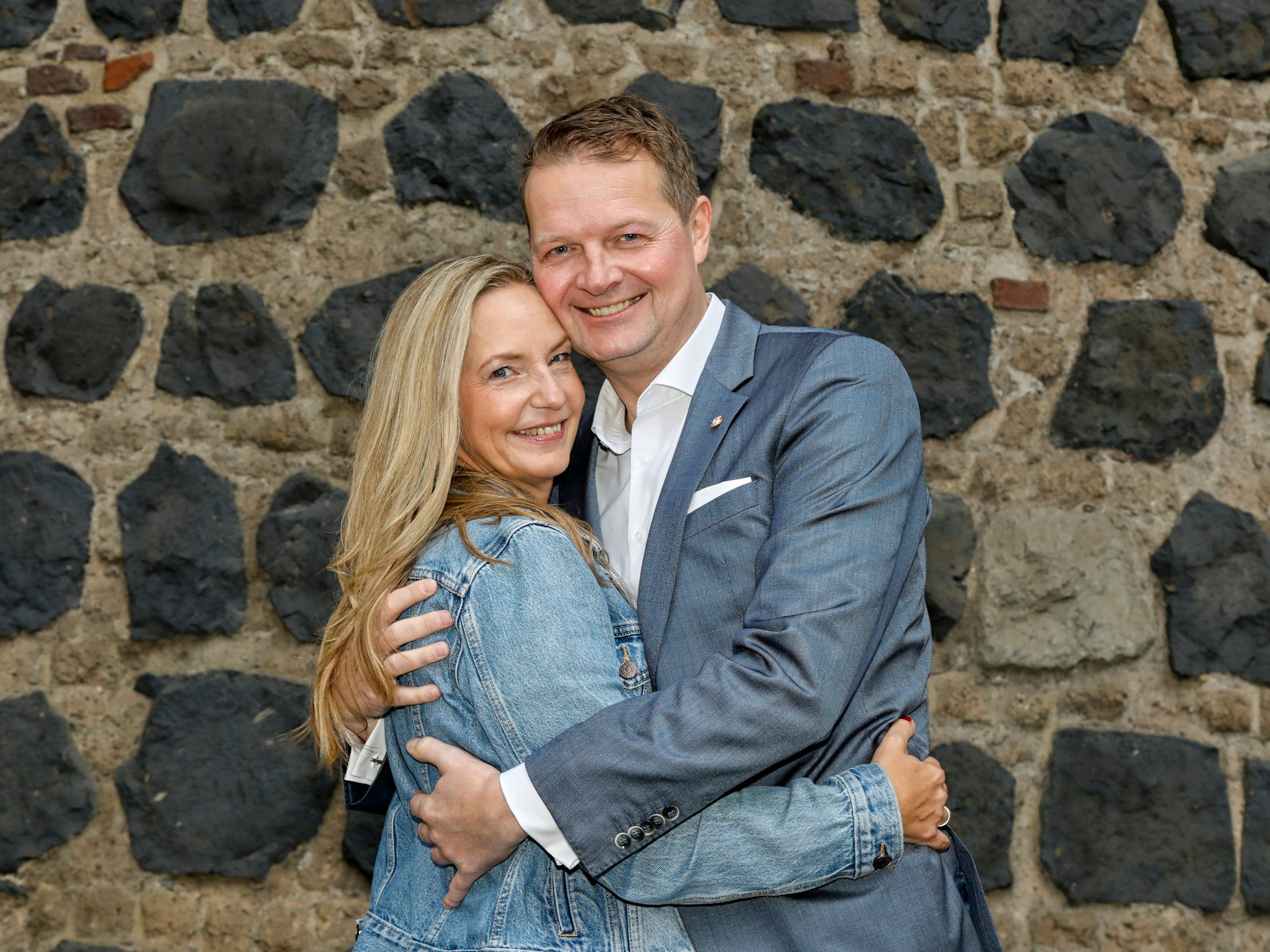 Der Kölner Prinz Boris hält Ehefrau Silke vor einer Steinwand im Arm.