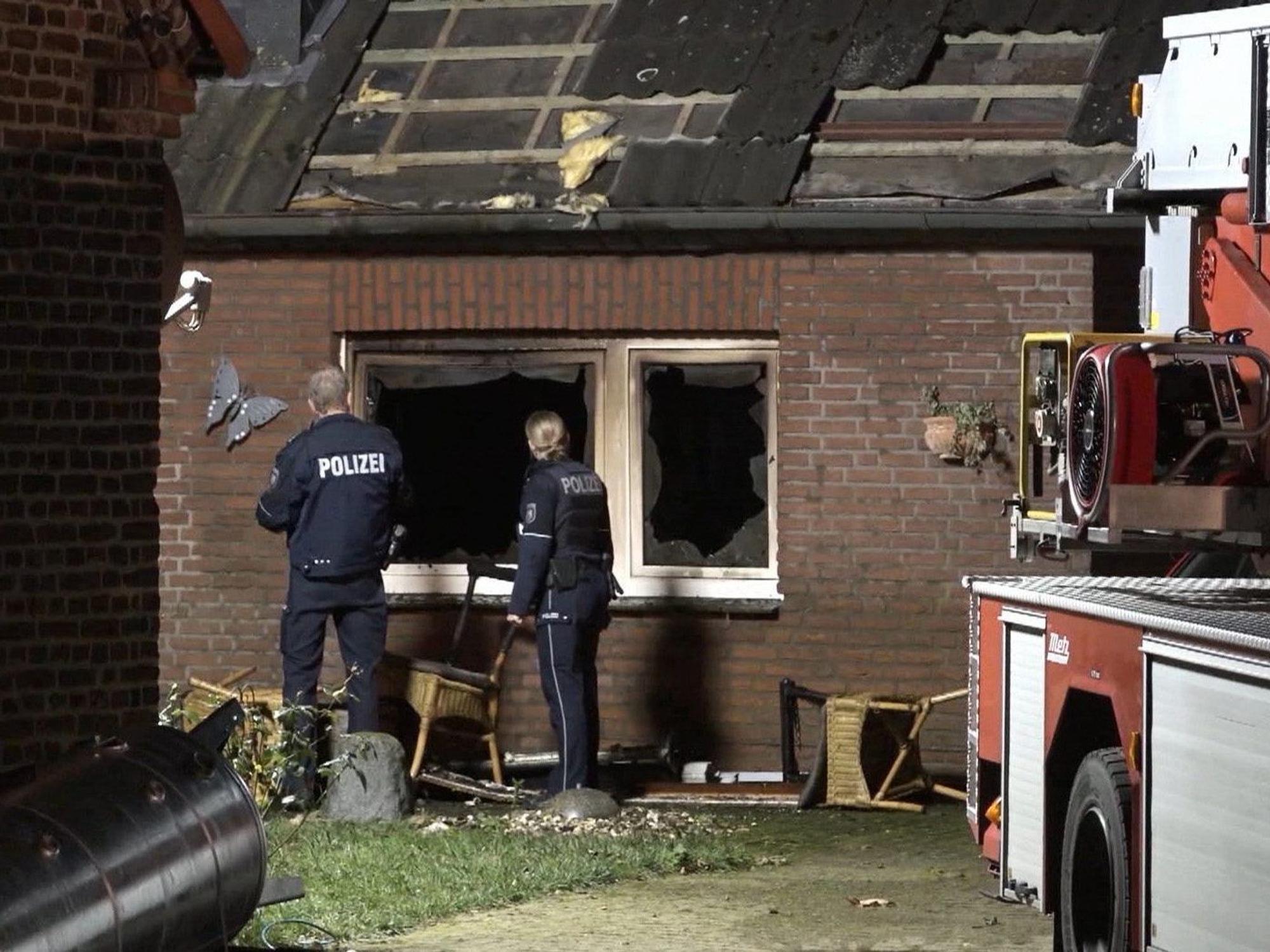 Nordrhein-Westfalen, Hamminkeln: Zwei Polizisten inspizieren den Brandort, wo eine Person ums Leben gekommen ist.