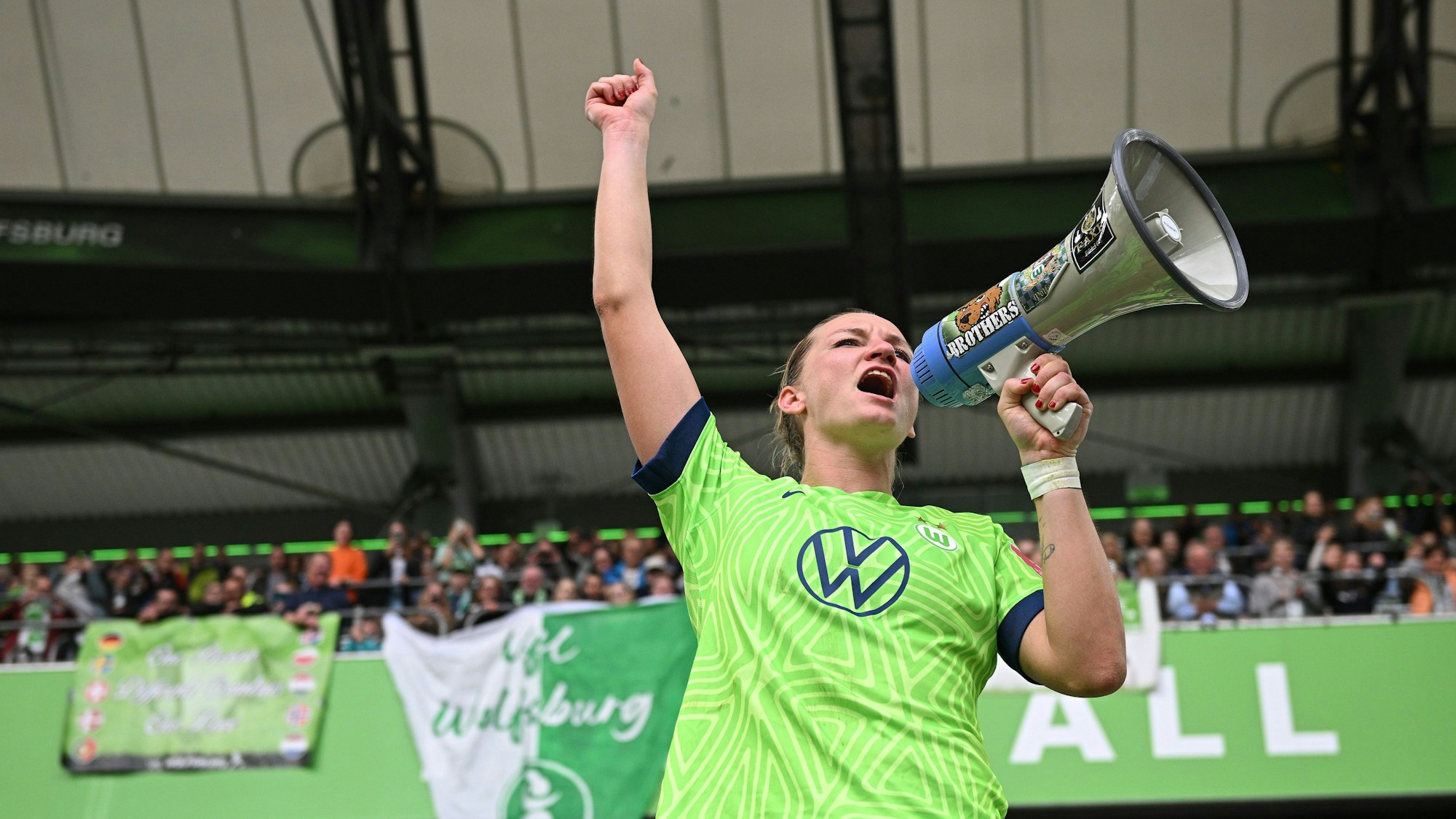 Alexandra Popp feiert mit Fans und Megafon.