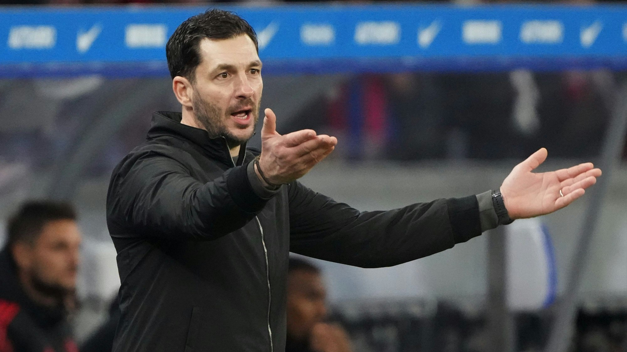 Herthas Cheftrainer Sandro Schwarz breitet an der Seitenlinie die Arme aus.