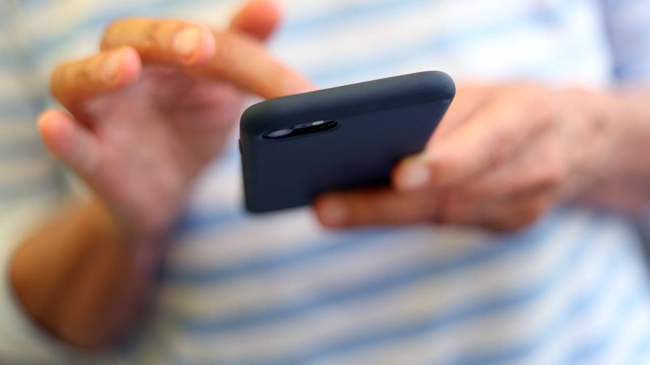 Eine Frau tippt auf einem Smartphone.