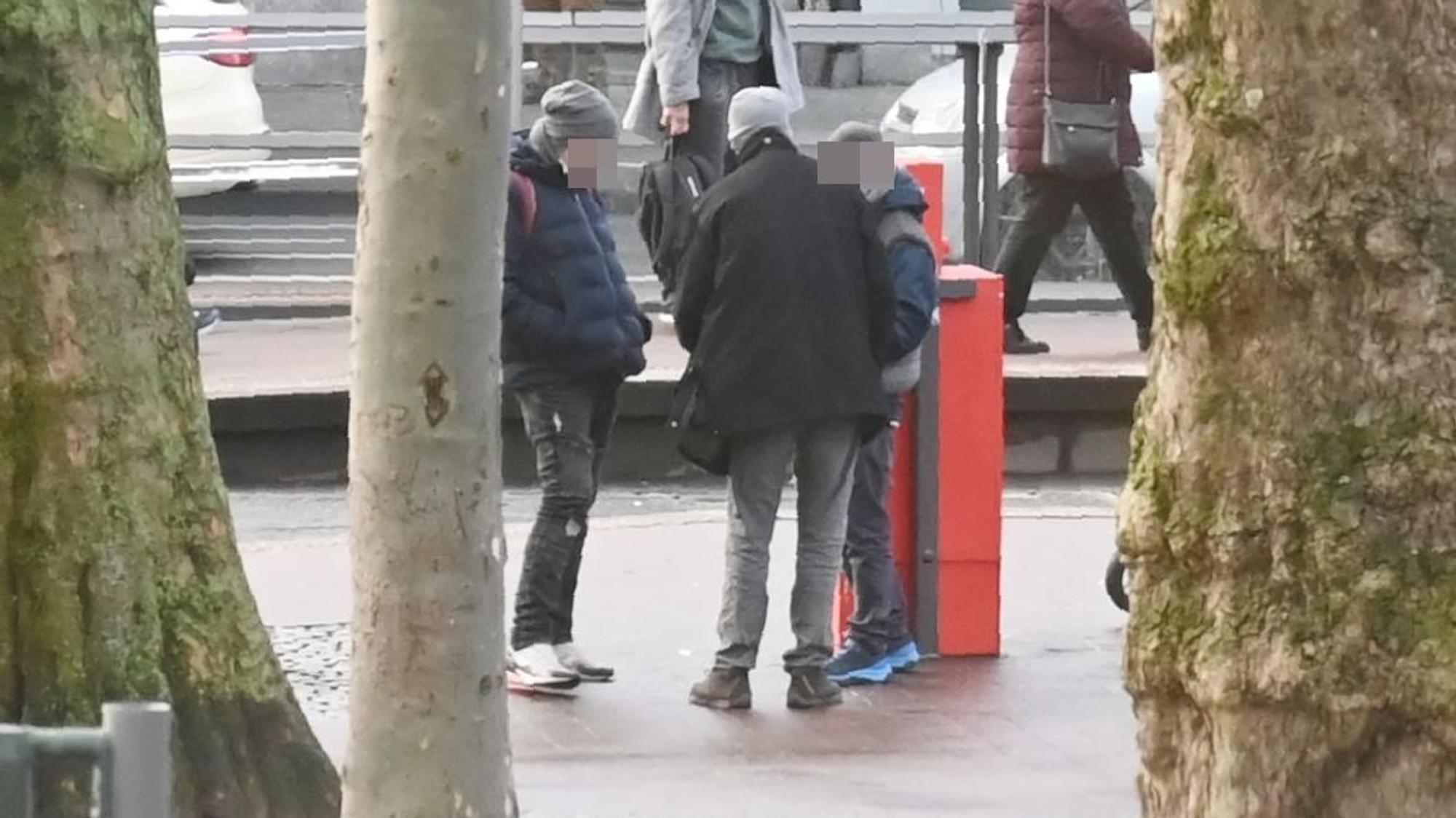 Mehrere Personen stehen am Neumarkt in Köln zusammen und verteilen Drogen unter sich.