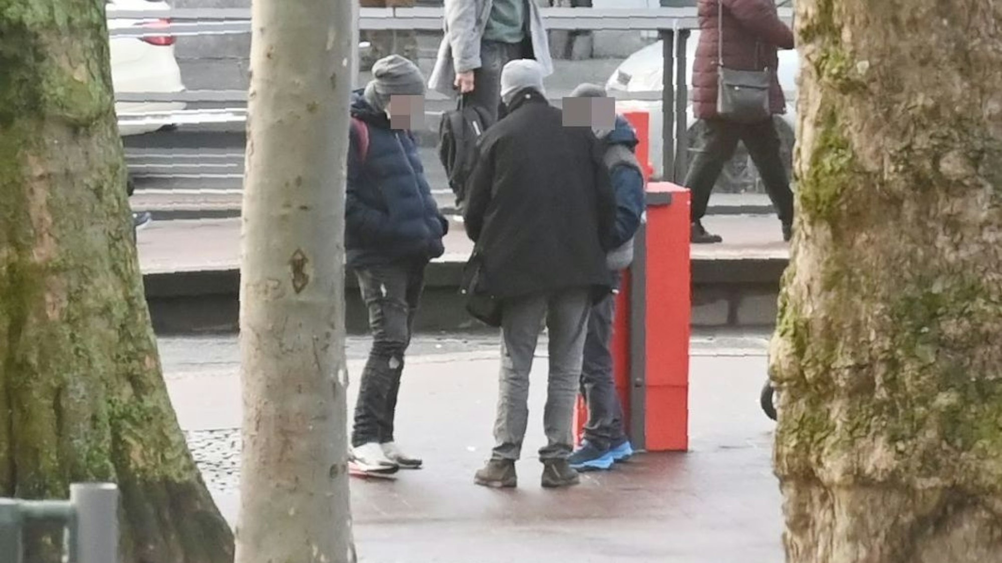 Mehrere Personen stehen am Neumarkt in Köln zusammen und verteilen Drogen unter sich.