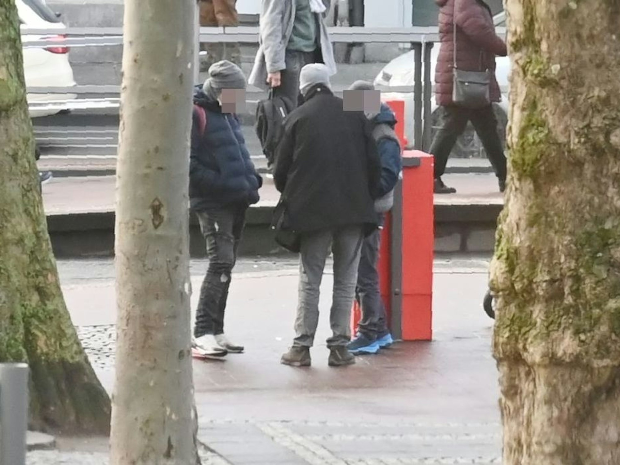 Mehrere Personen stehen am Neumarkt in Köln zusammen und verteilen Drogen unter sich.