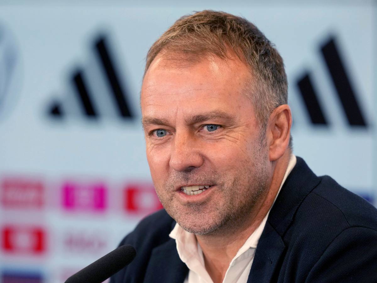Hansi Flick sitzt bei der Verkündung seines DFB-Aufgebots für die WM 2022 in Katar am Rednerpult