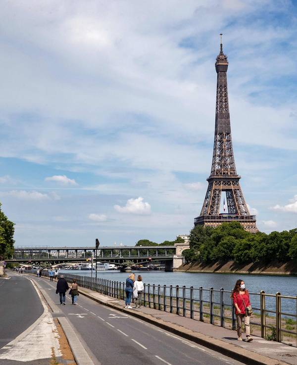 Unser Foto zeigt den Eiffelturm in Paris vor blauem Himmel und vielen Wolken.