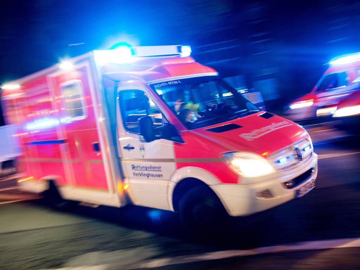 Ein Rettungswagen der Feuerwehr fährt mit Blaulicht durch eine Straße.