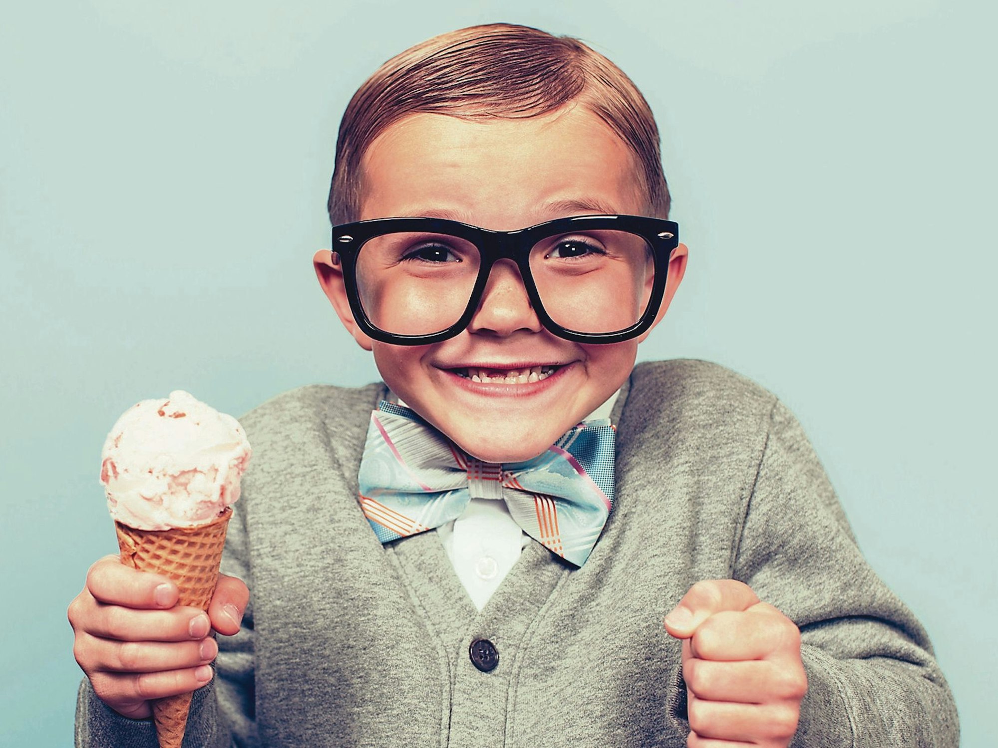 Kleiner Junge im Retro-Look freut sich über ein Eis.