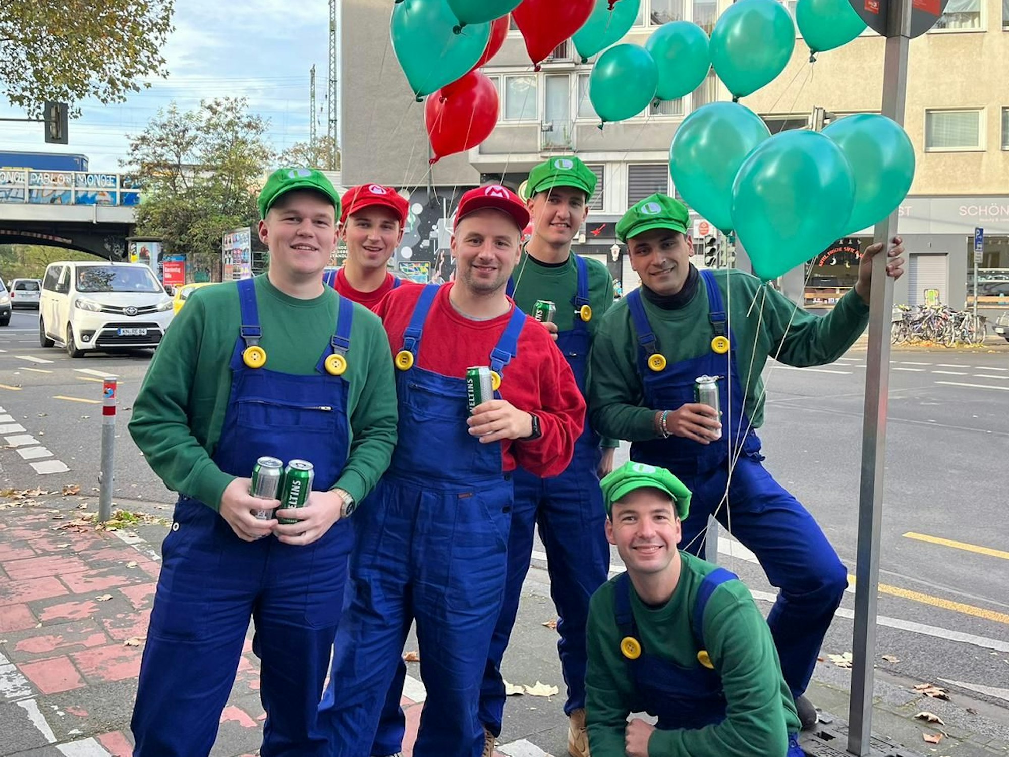Sechs Freunde in Kostümen von Mario und Luigi posieren in Köln für die Kamera.
