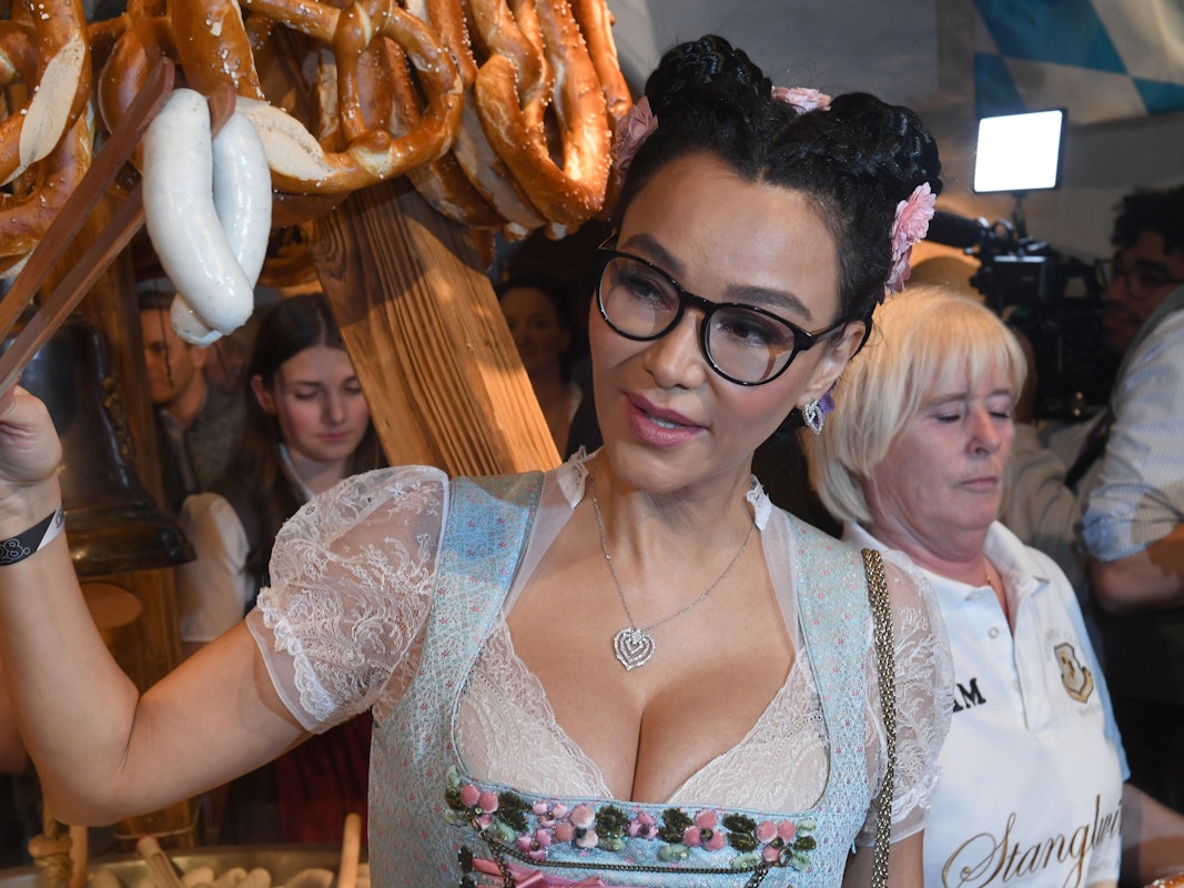 Verona Pooth hält bei der Weißwurstparty im Stanglwirt Weißwürste mit einer Weißwurstzange.