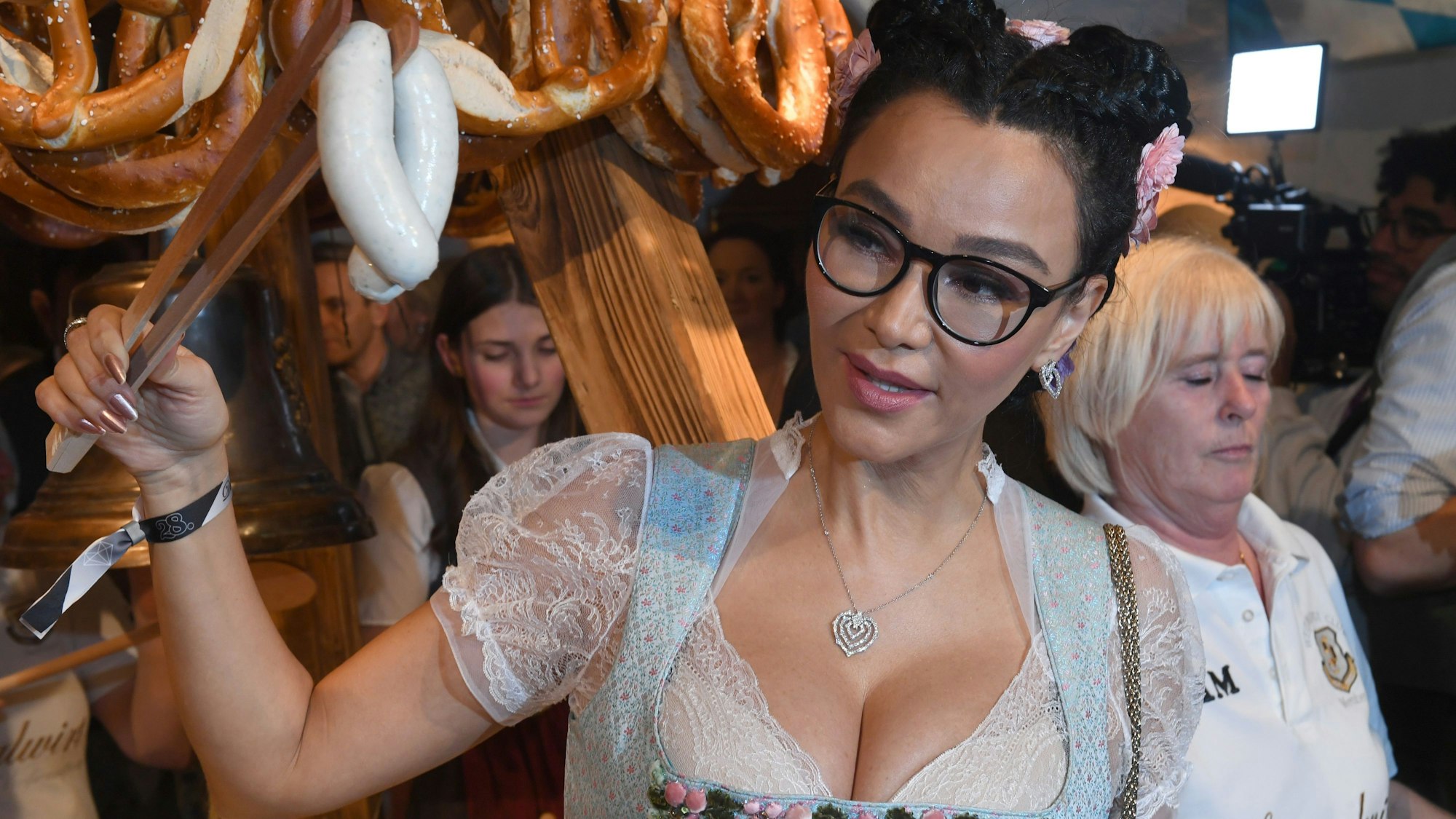 Verona Pooth hält bei der Weißwurstparty im Stanglwirt Weißwürste mit einer Weißwurstzange.