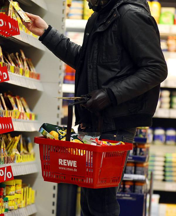 Ein Kunde steht in Köln in einem Rewe-Supermarkt an einem Regal (Symbolfoto).