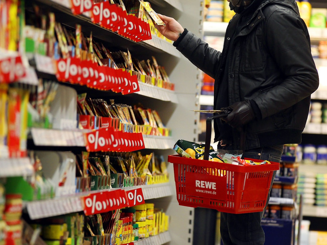 Ein Kunde steht in Köln in einem Rewe-Supermarkt an einem Regal (Symbolfoto).