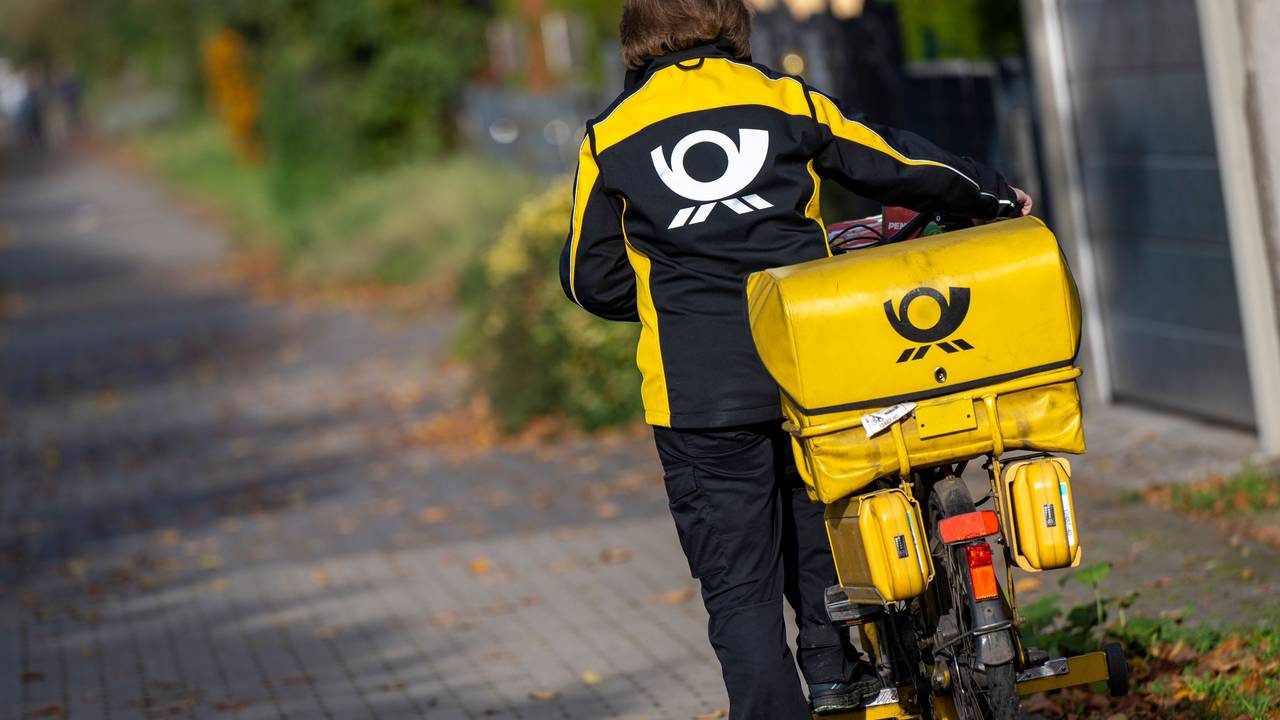 Eine Briefträgerin der Deutschen Post steigt auf ihr Postfahrrad. Die Deutsche Post hat bei der Zustellung von Briefen erhebliche Probleme eingeräumt.