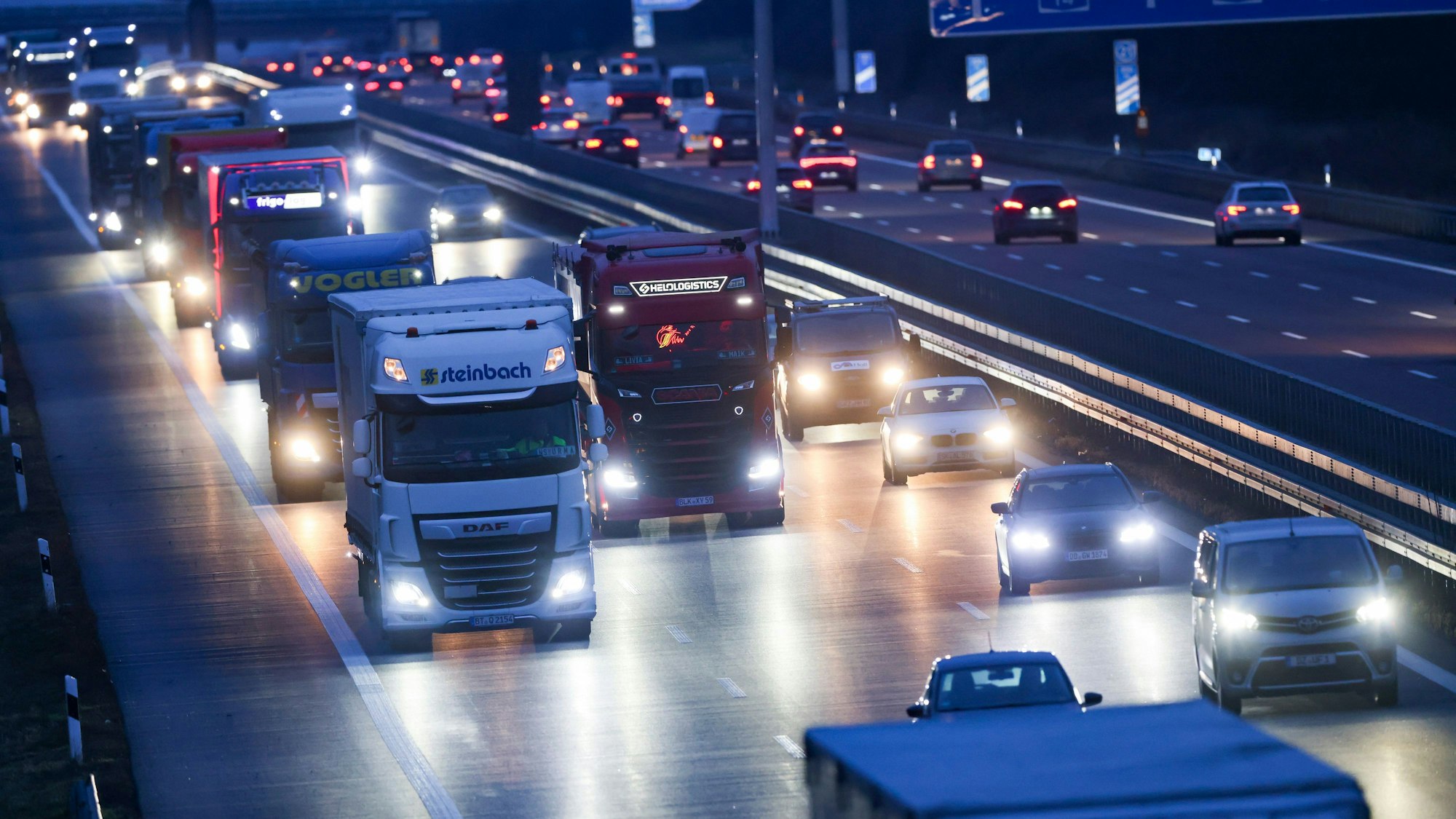 Autos und Lastkraftwagen fahren am frühen Morgen über die A14 bei Radefeld.