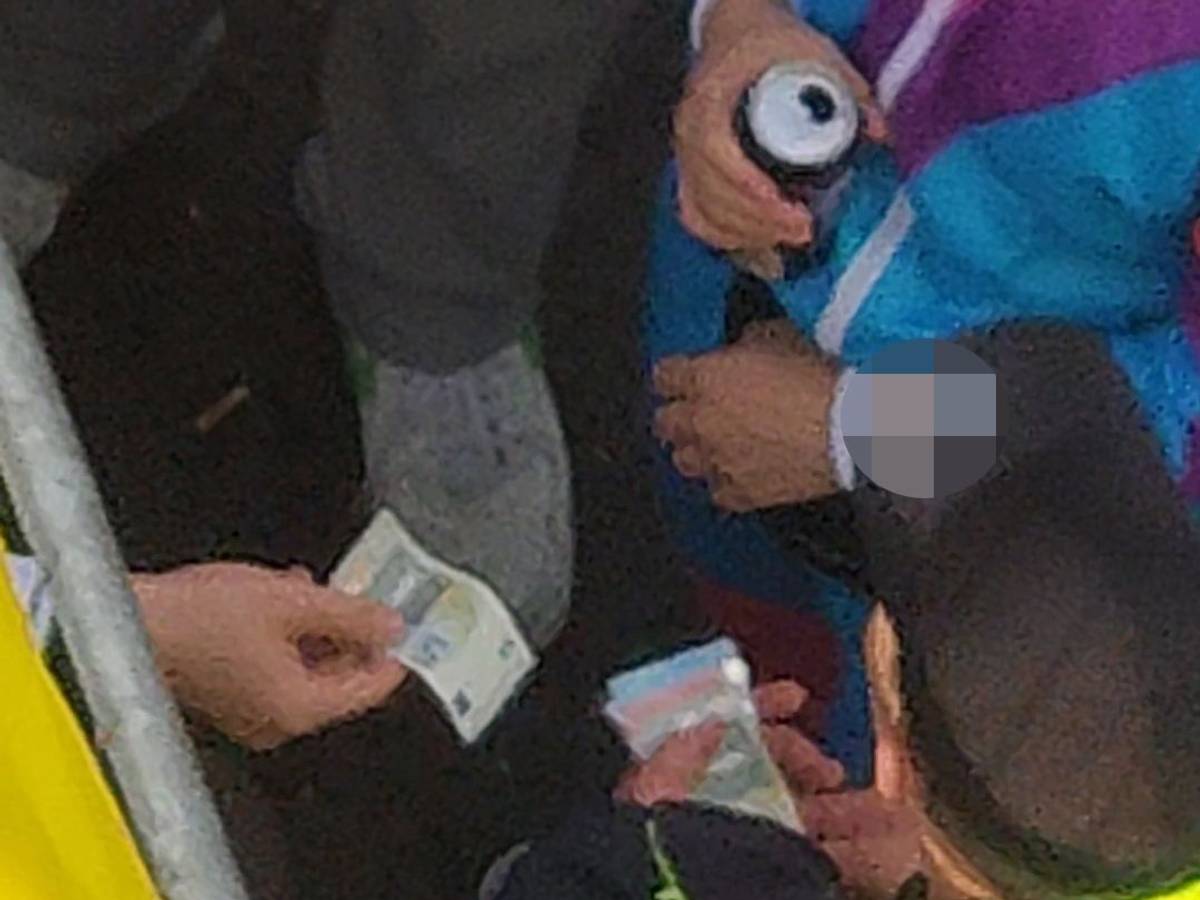 Ein Ordner nimmt einen Fünf-Euro-Schein von einem Feiernden entgegen. Die Szene wurde am 11.11.2022 am Ausgangsbereich der Zülpicher Straße aufgenommen.