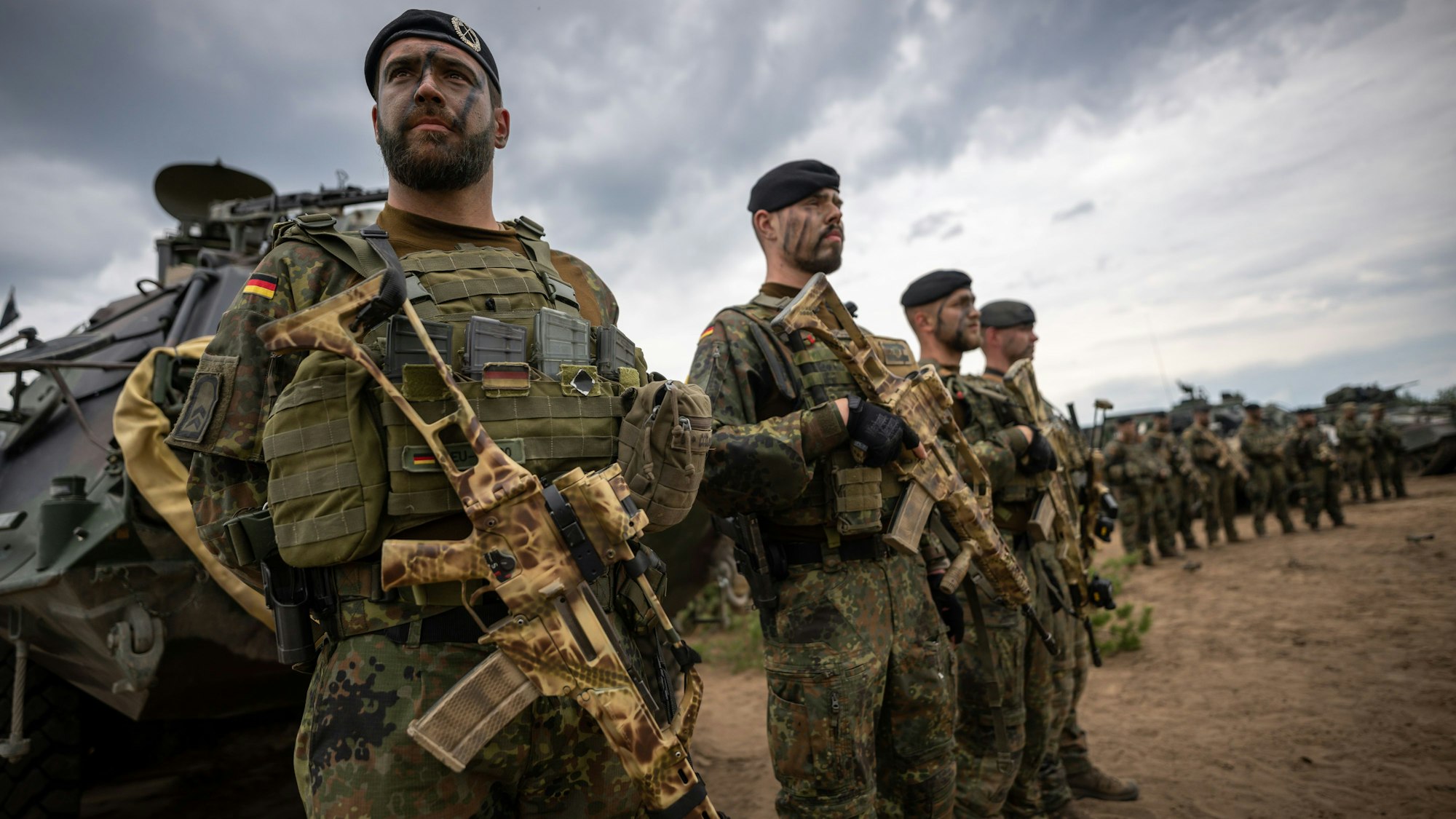 Soldaten der Bundeswehr, der NATO Enhanced Forward Presence Battle Group (eFP-Bataillon) stehen beim Besuch von Kanzler Scholz im Camp Adrian Rohn.