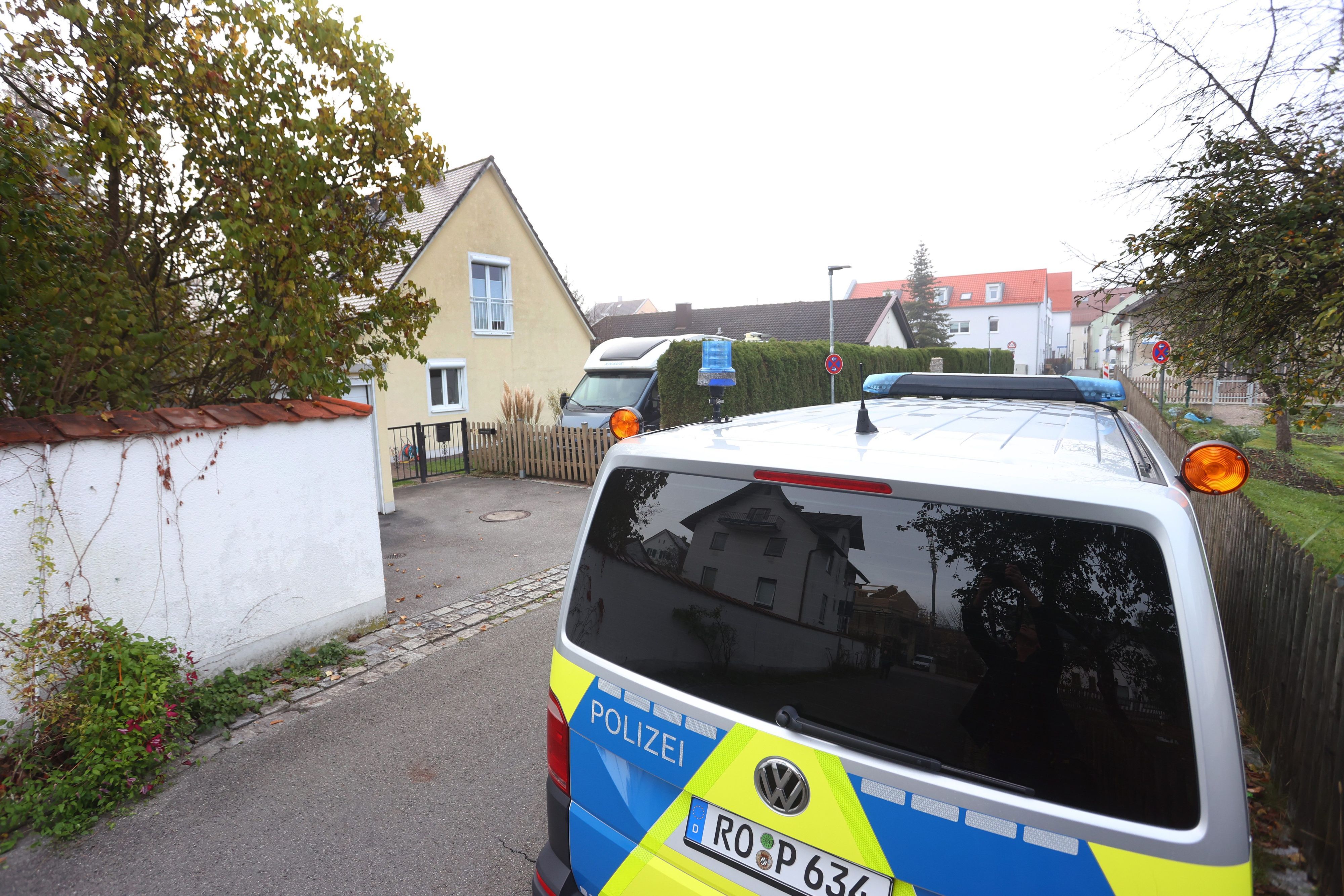 Ein Polizeiauto steht vor dem Haus in Weilheim, in dem es zu der Bluttat mit vier Toten gekommen ist.