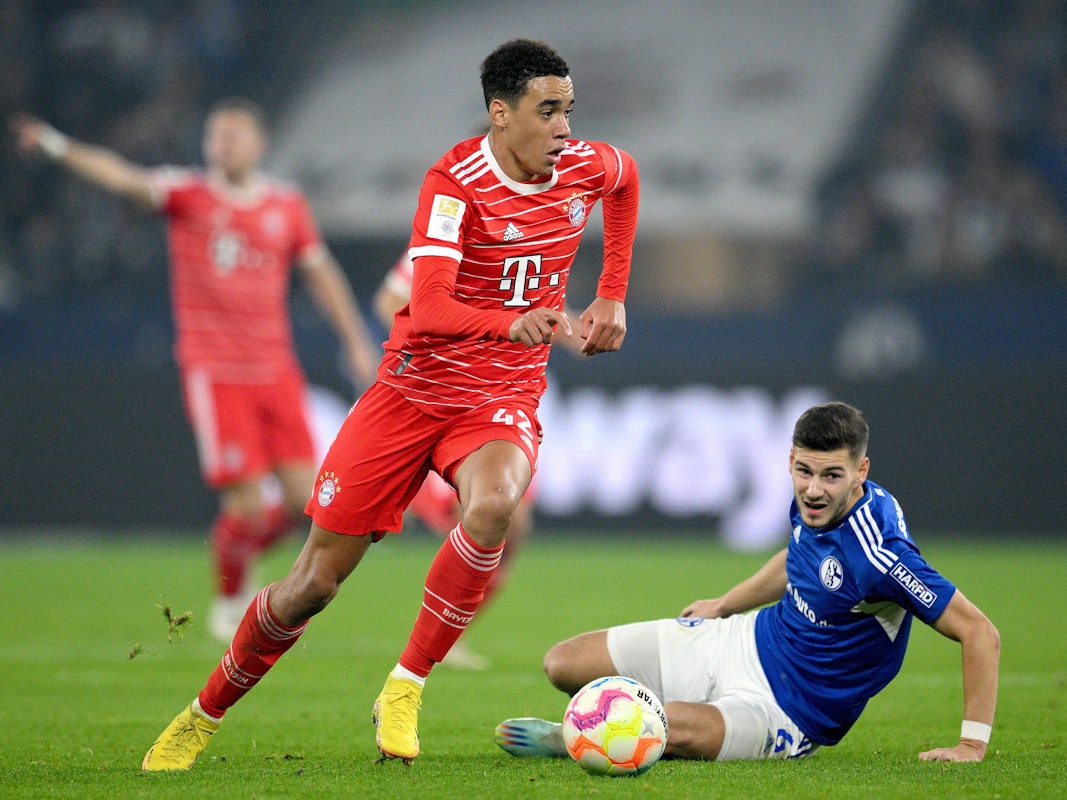 Jamal Musiala umkurvt mit dem Ball Tom Krauß vom FC Schalke 04.