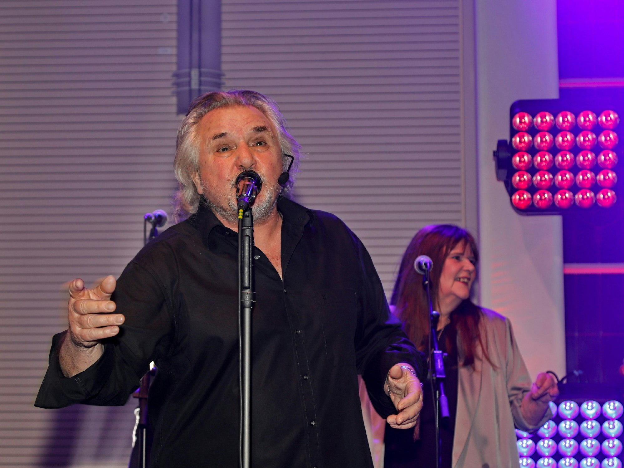 Tommy Engel steht mit Mikrofon auf der Bühne und singt bei den Blauen Funken.