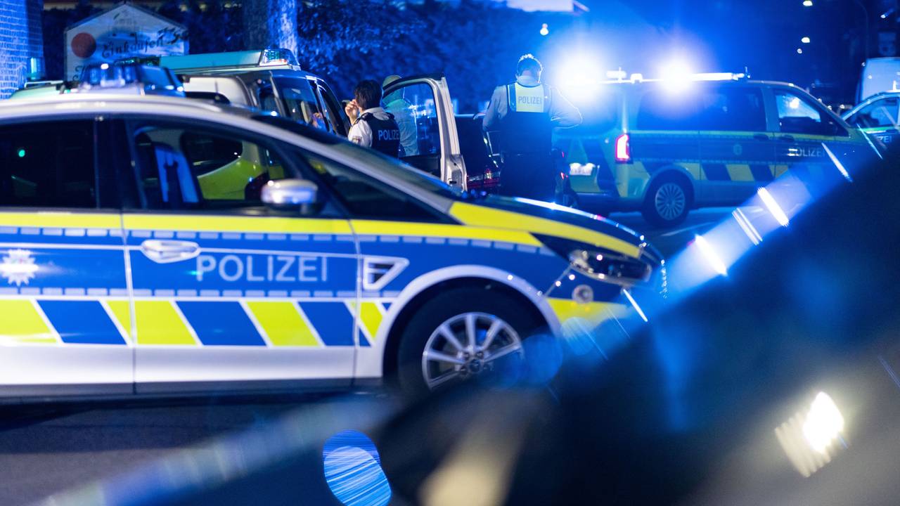 Einsatzkräfte der Polizei stehen vor einer Tankstelle.