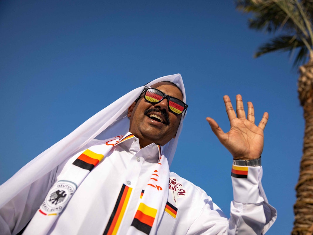 Ein Fußballfan winkt in die Kamera.
