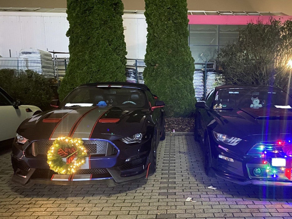Sogenannte Muscle-Cars mit Weihnachtsdekoration sind auf einem Parkplatz in Ramstein-Miesenbach abgestellt.