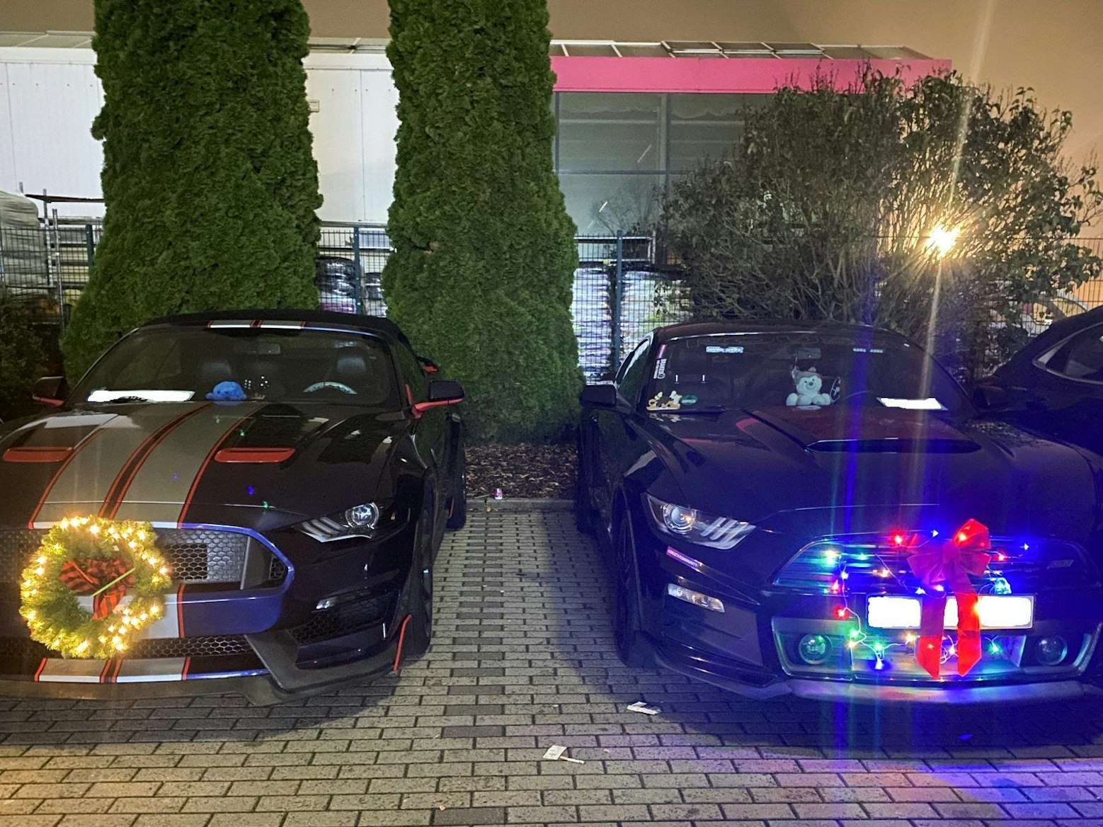 Sogenannte Muscle-Cars mit Weihnachtsdekoration sind auf einem Parkplatz in Ramstein-Miesenbach abgestellt.