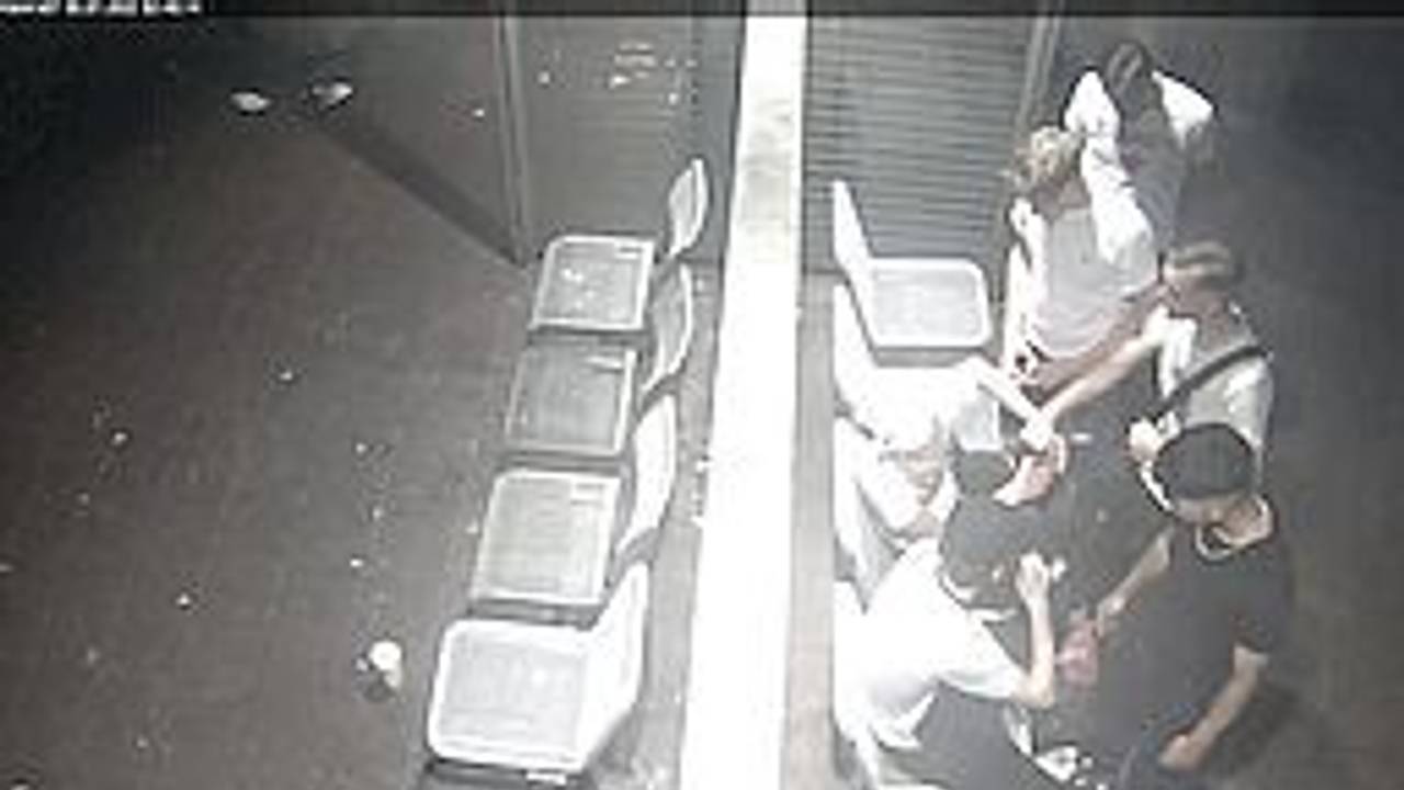 Vier junge Männer stehen vor zwei Männern, die sich gegen sie wehren wollen. Das Foto ist von oben aufgenommen und stammt aus einer Überwachungskamera.