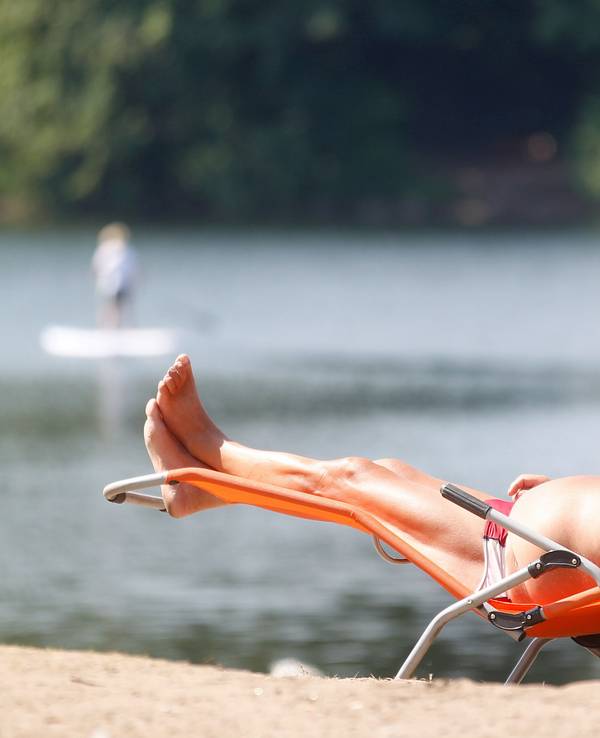 Ein Sonnenbad nimmt ein Badegast am Masurensee.