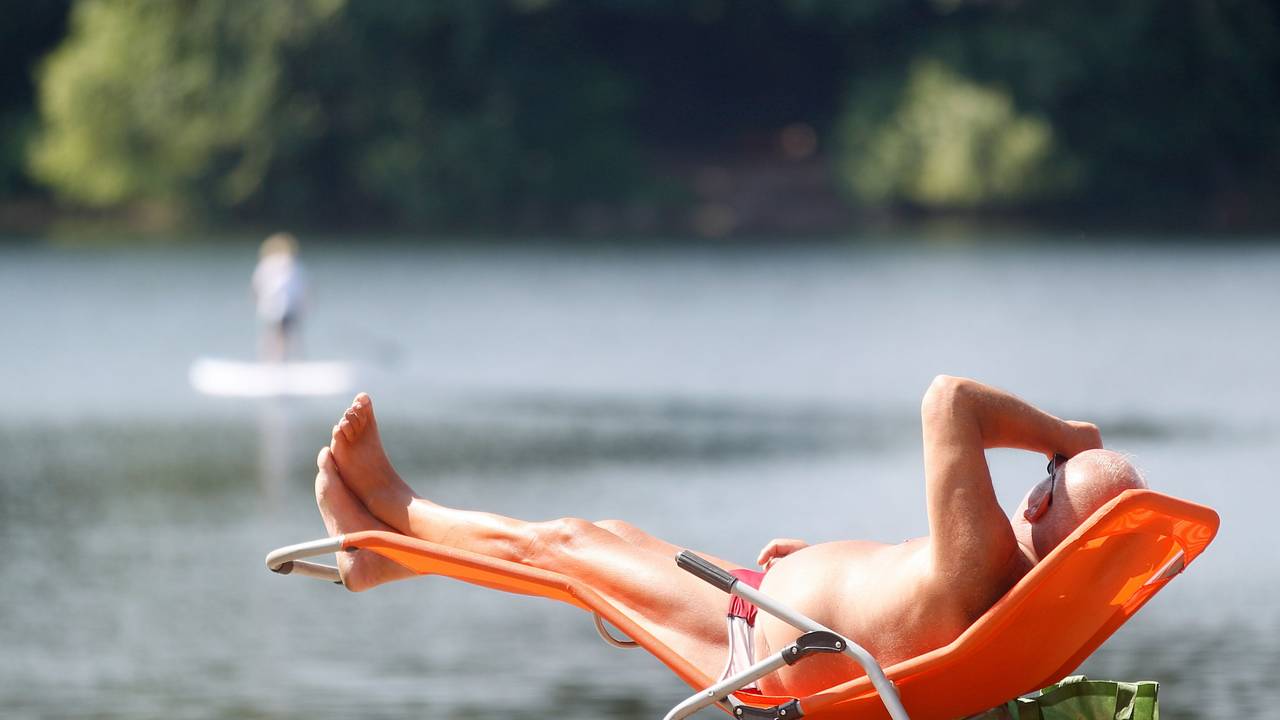 Ein Sonnenbad nimmt ein Badegast am Masurensee.