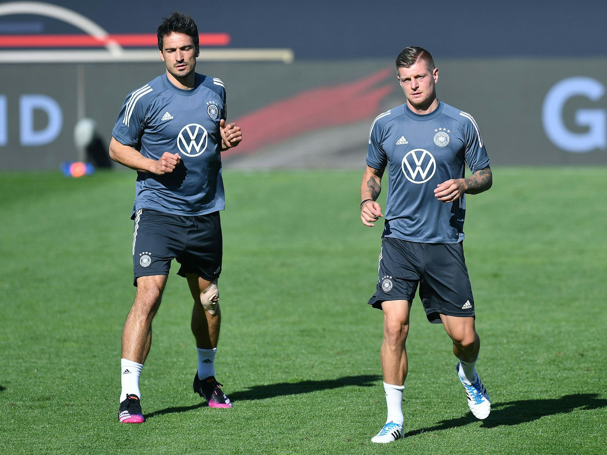 Mats Hummels und Toni Kroos laufen.