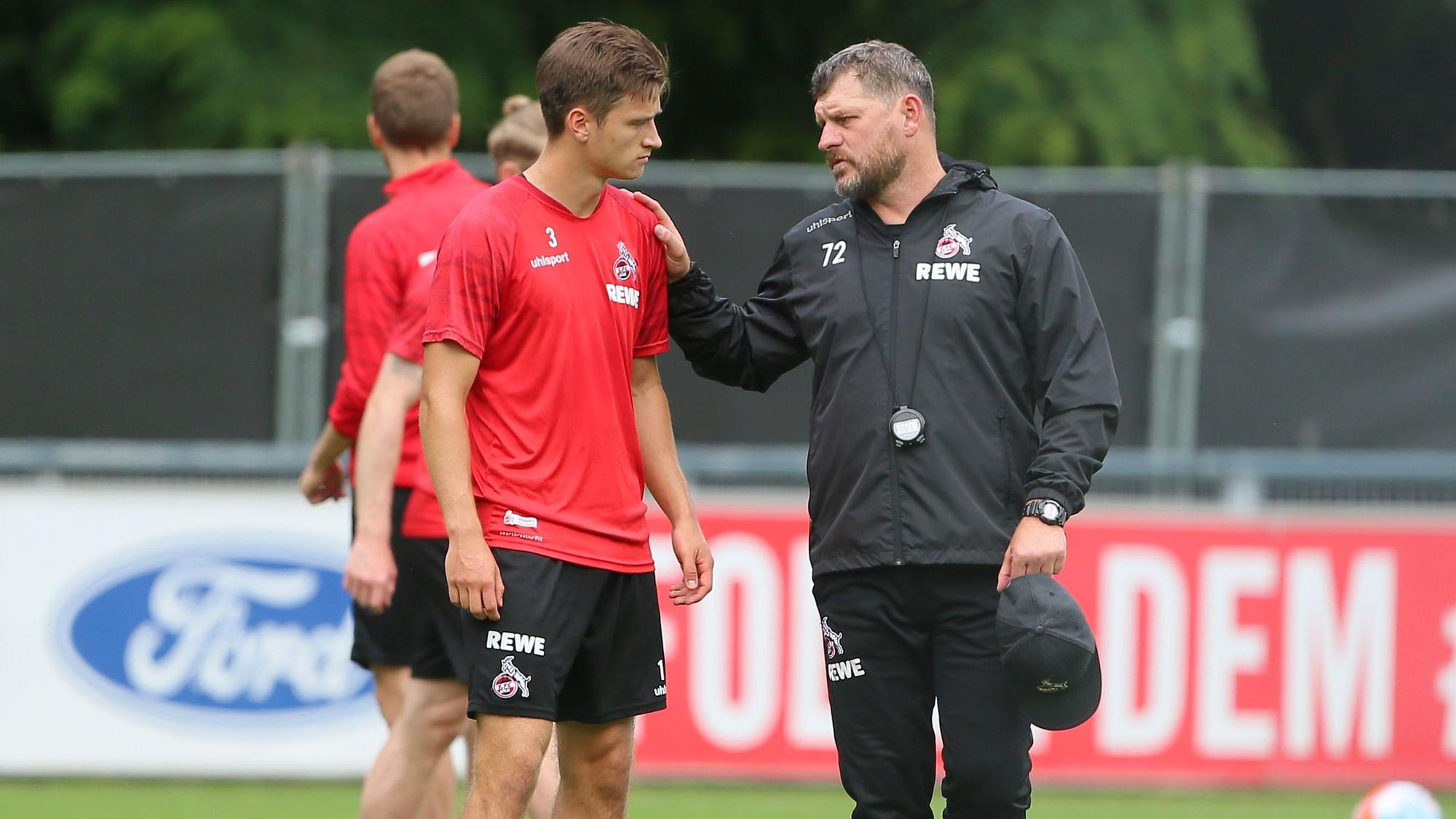 Steffen Baumgart spricht beim Training des 1. FC Köln mit Noah Katterbach.