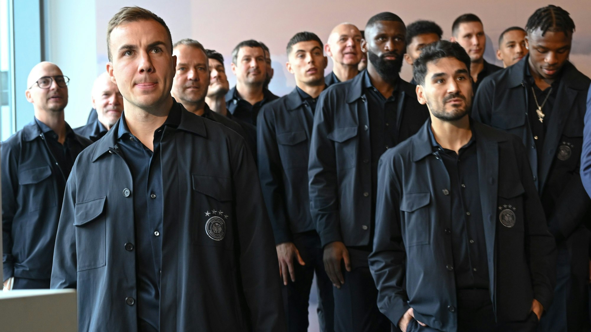 Nationalspieler Mario Götze (l) nimmt zusammen mit den Nationalspielern, Trainern und Betreuern vor dem Abflug der Fußball-Nationalmannschaft ins Kurz-Trainingslager nach Maskat an einer Verabschiedung im Lufthansa First Class Terminal teil.