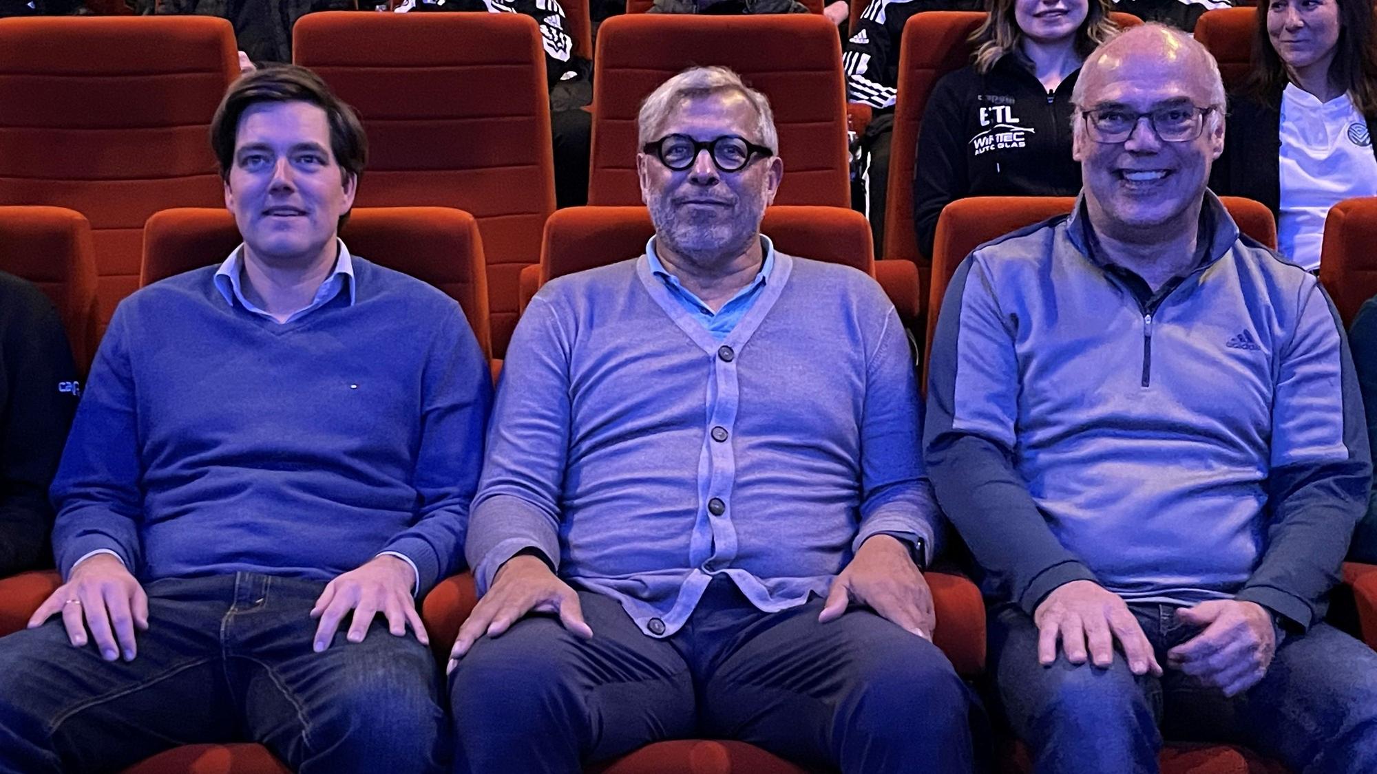 Jimmy Hartwig (M.) sitzt mit Viktoria-Geschäftsführer Axel Freisewinkel (l.) und FVM-Geschäftsführer Dirk Brennecke im Kino.