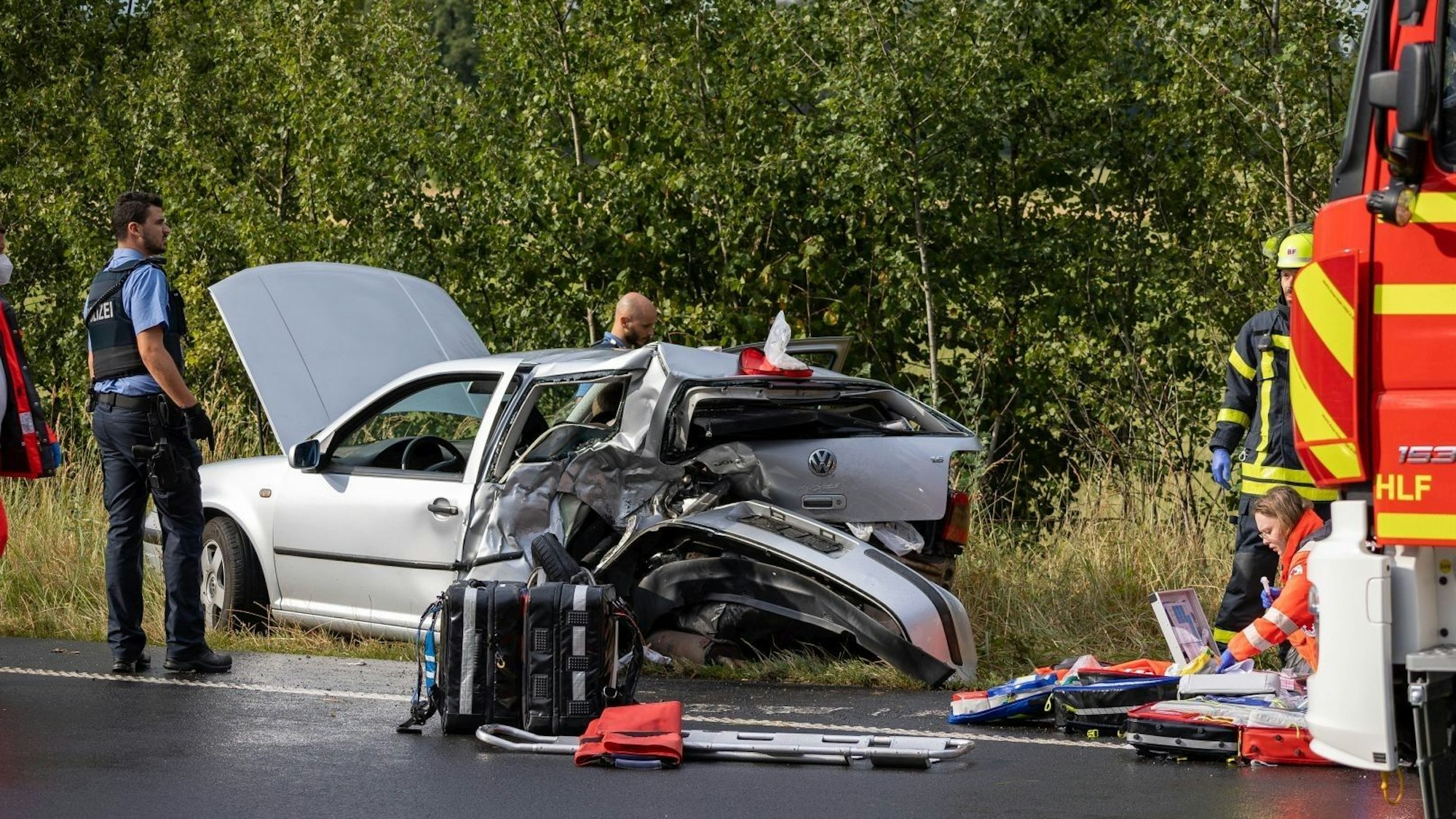 Rettungskräfte stehen am Unfallort.