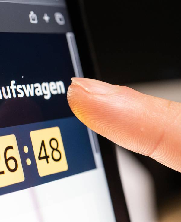 Das Symbolfoto zeigt eine Person, die auf einem Tablet auf den Amazon-Warenkorb klickt.