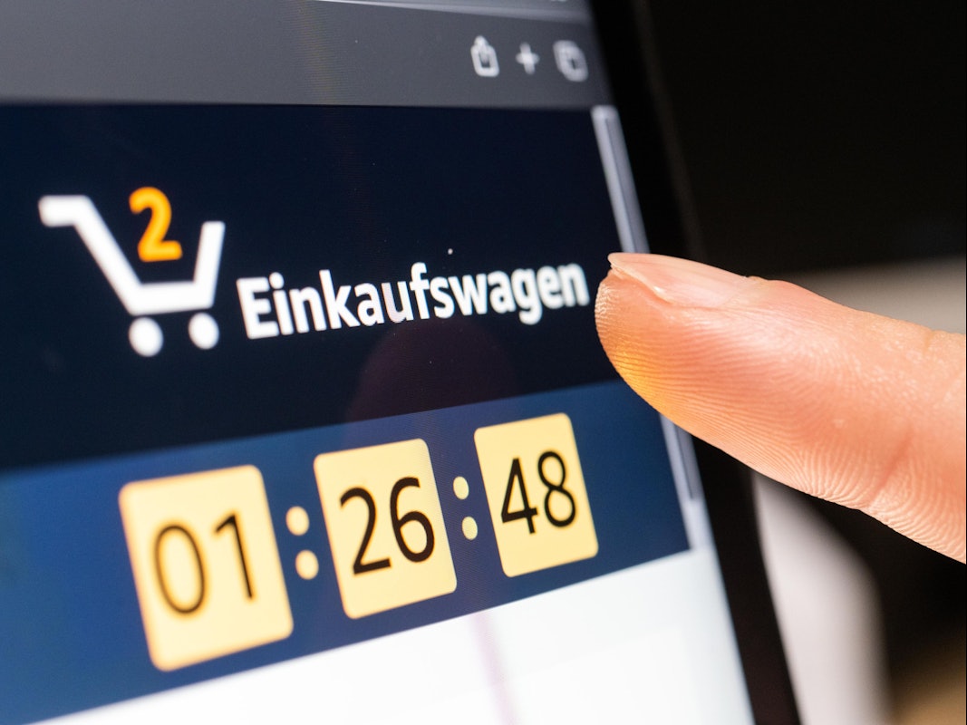 Das Symbolfoto zeigt eine Person, die auf einem Tablet auf den Amazon-Warenkorb klickt.