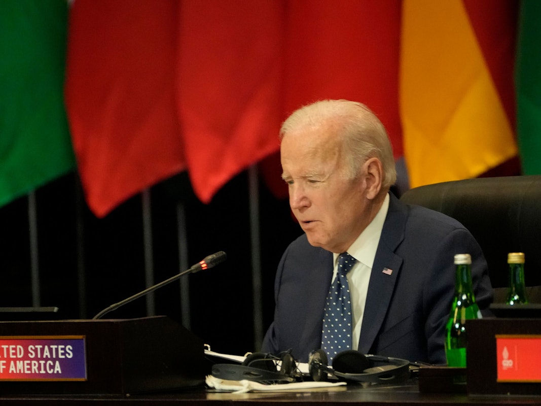 Das Foto zeigt den US-Präsident Joe Biden während des G20-Gipfels. Er spricht in ein Mikrofon, hinter ihm befinden sich Flaggen.