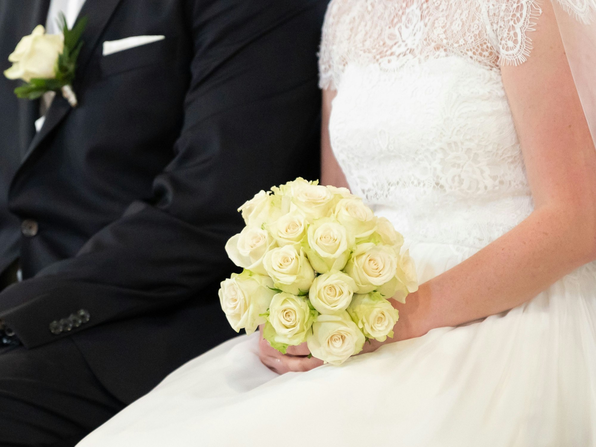 Ein Brautpaar sitzt während ihrer Trauung in der Kirche.