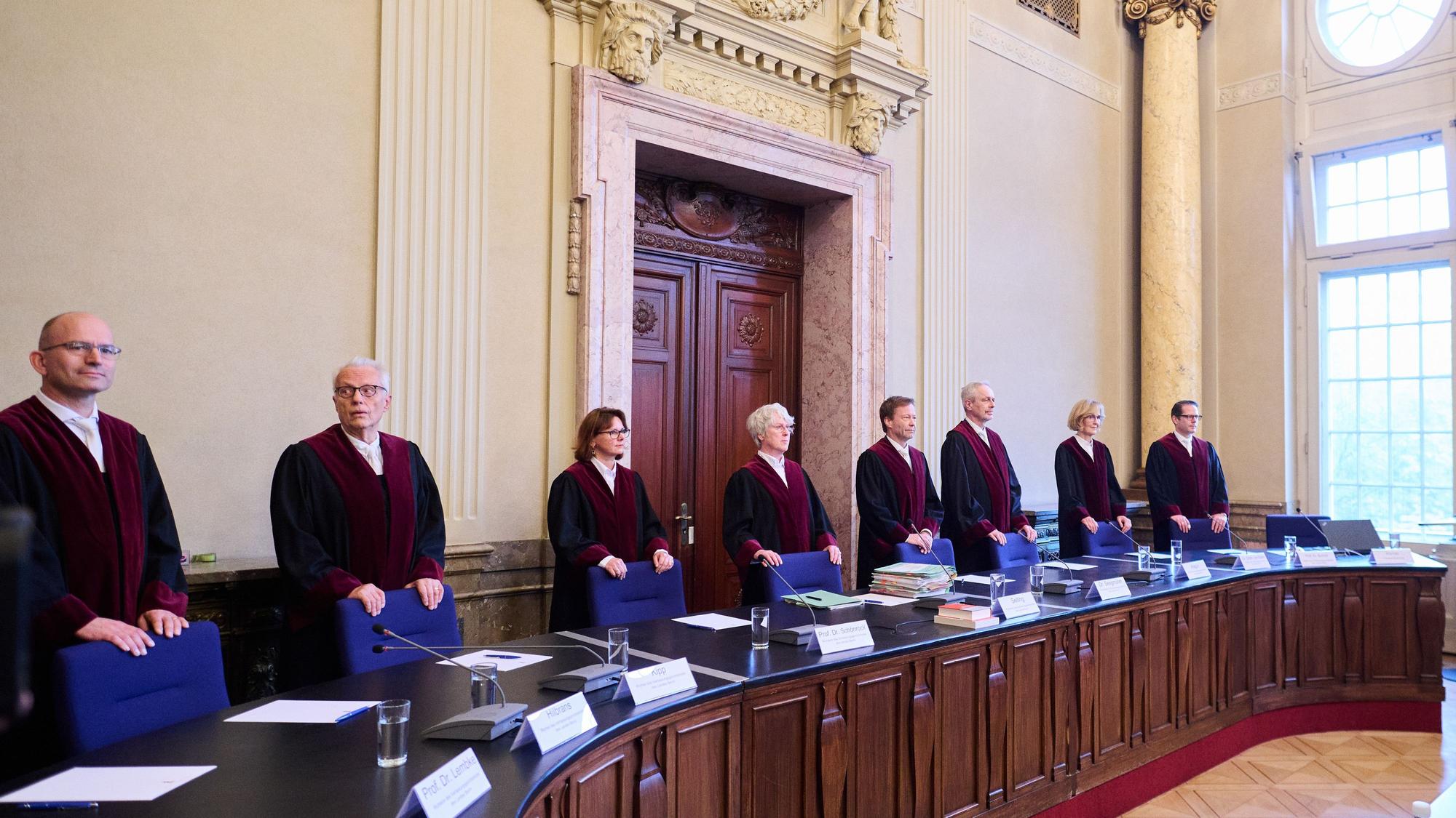 Die Richterinnen und Richter des Verfassungsgerichtshofes Sönke Hilbrans (l-r), Jürgen Kipp, Sabrina Schönrock, Ludgera Selting (Präsidentin), Robert Wolfgang Seegmüller, Ahmet Kurt Alagün, Margarete Gräfin von Galen und Christian Burholt stehen im Verfassungsgericht.