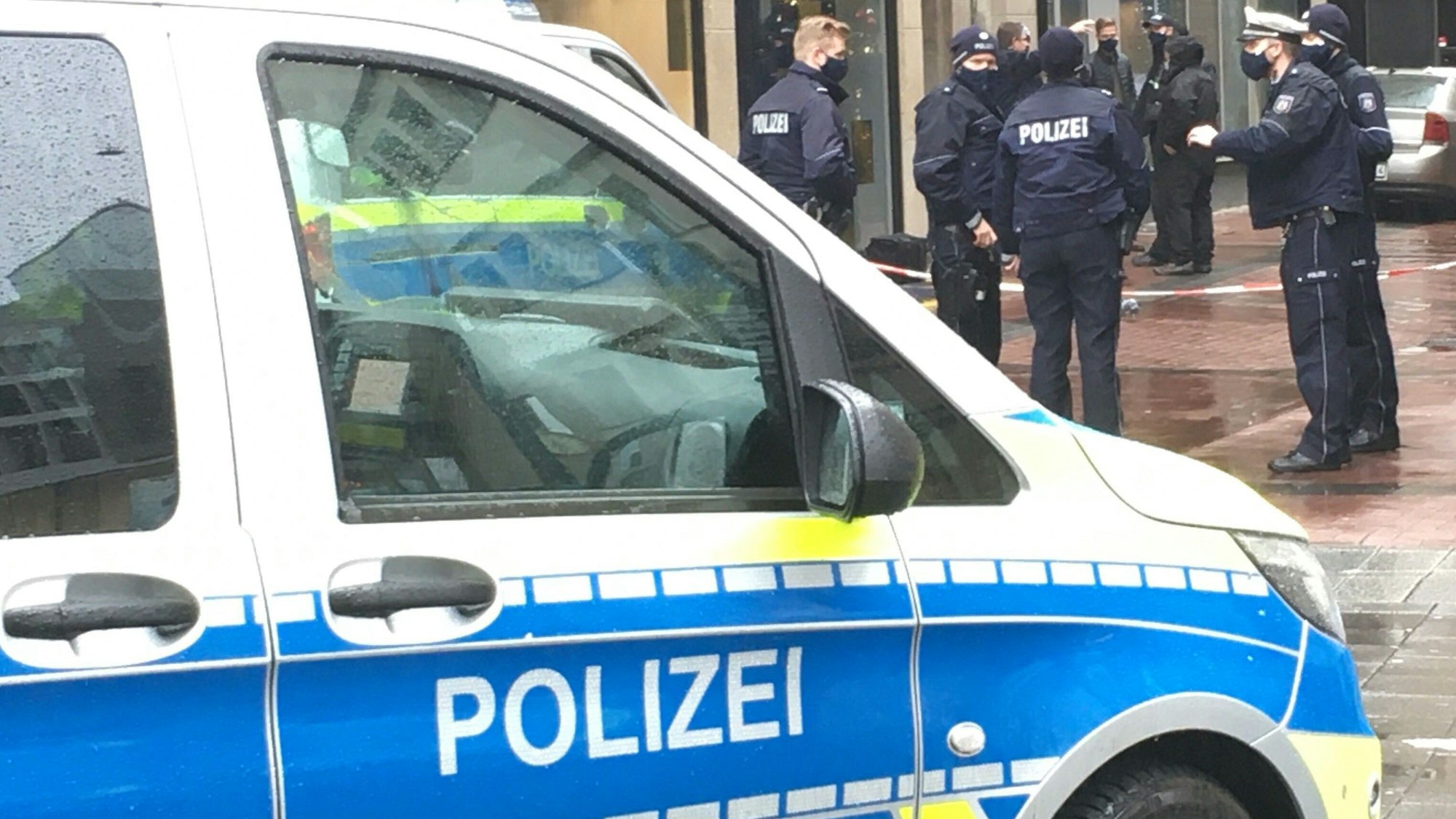 Polizisten stehen vor einem Geschäft.